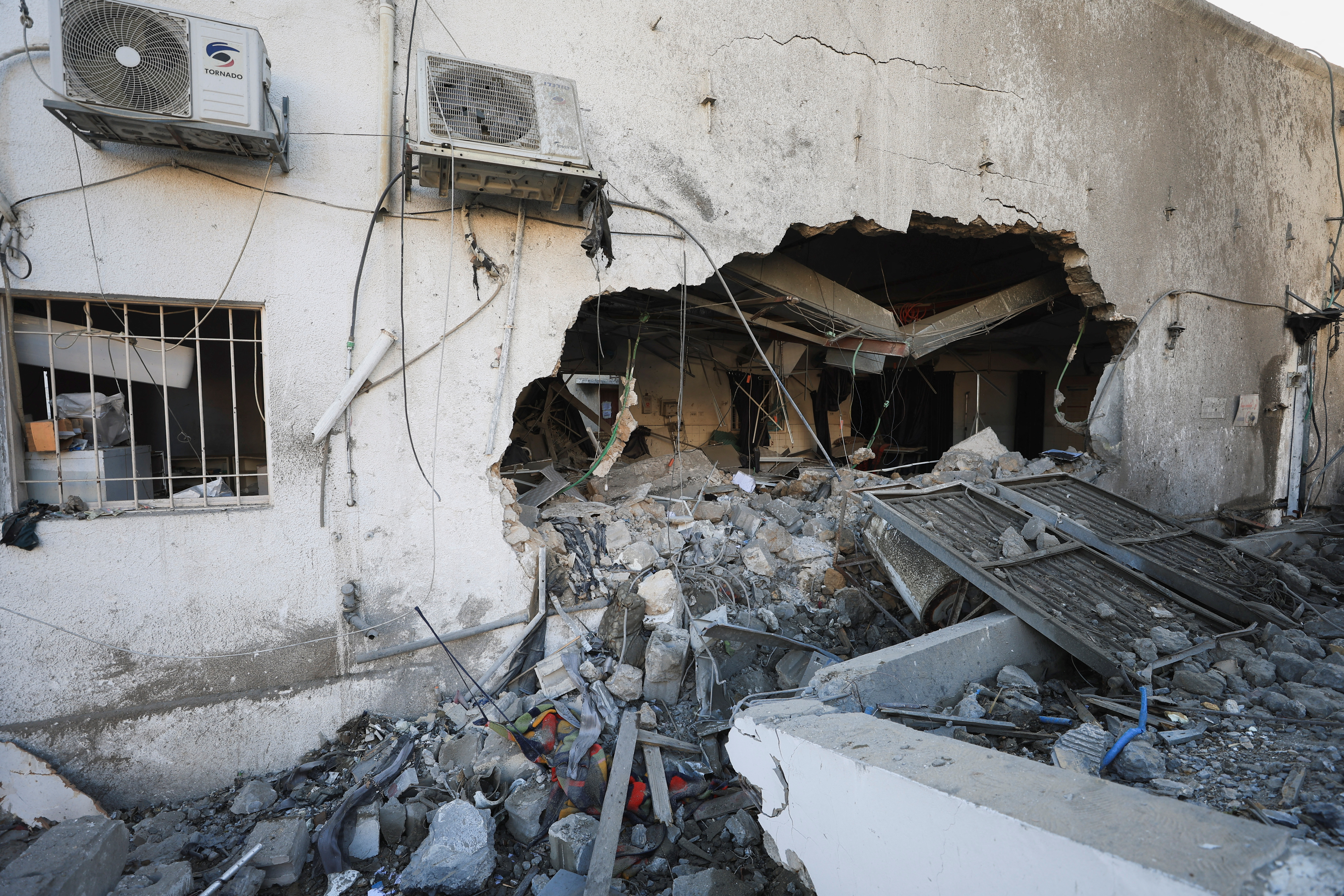 Palestinians inspect damage inside the Al-Ahli Arab Baptist Hospital in Gaza City