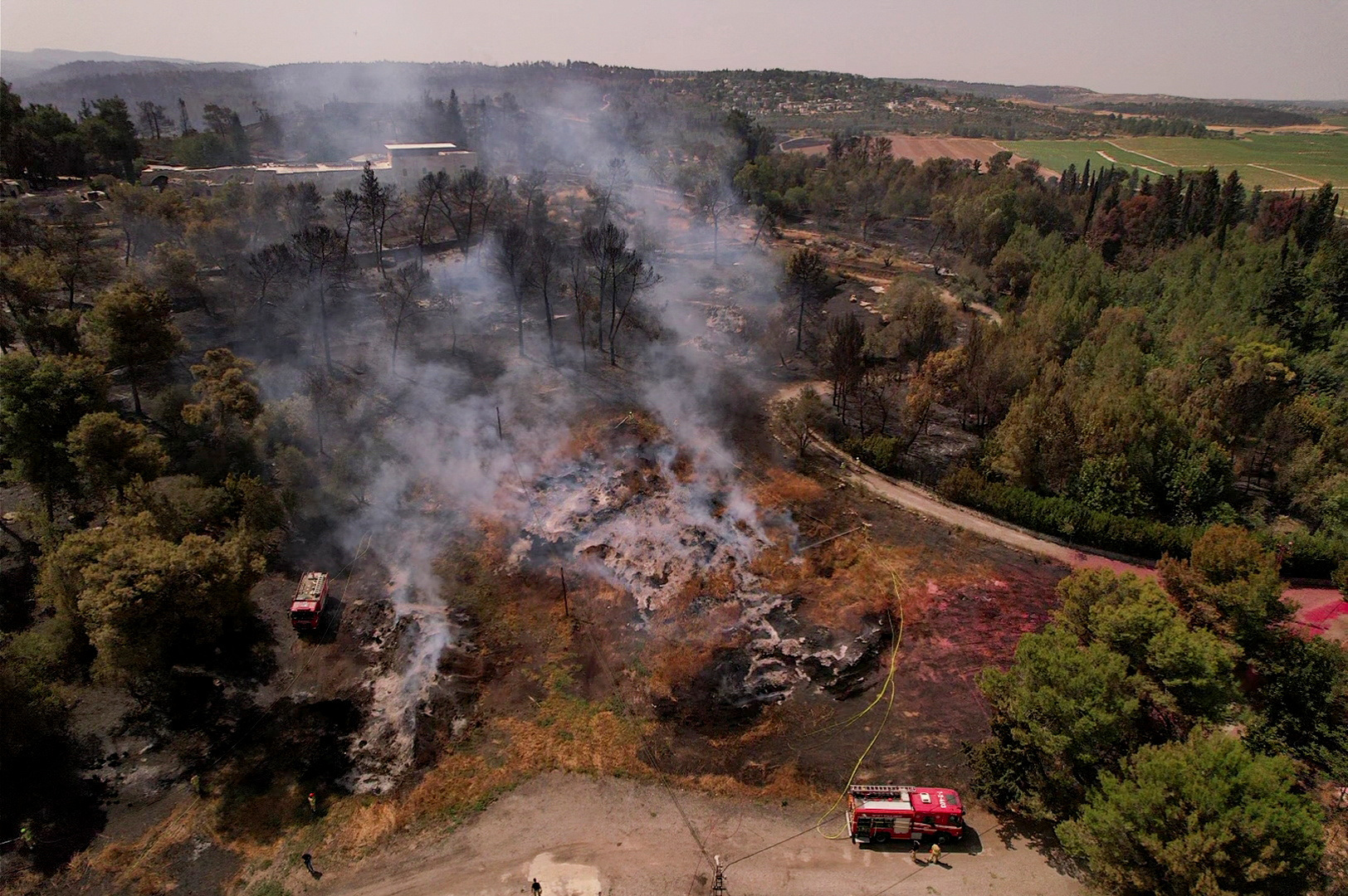 A drone view shows smoke rising near Latrun, a day after wildfires broke out due to extreme heat and winds, in central Israel