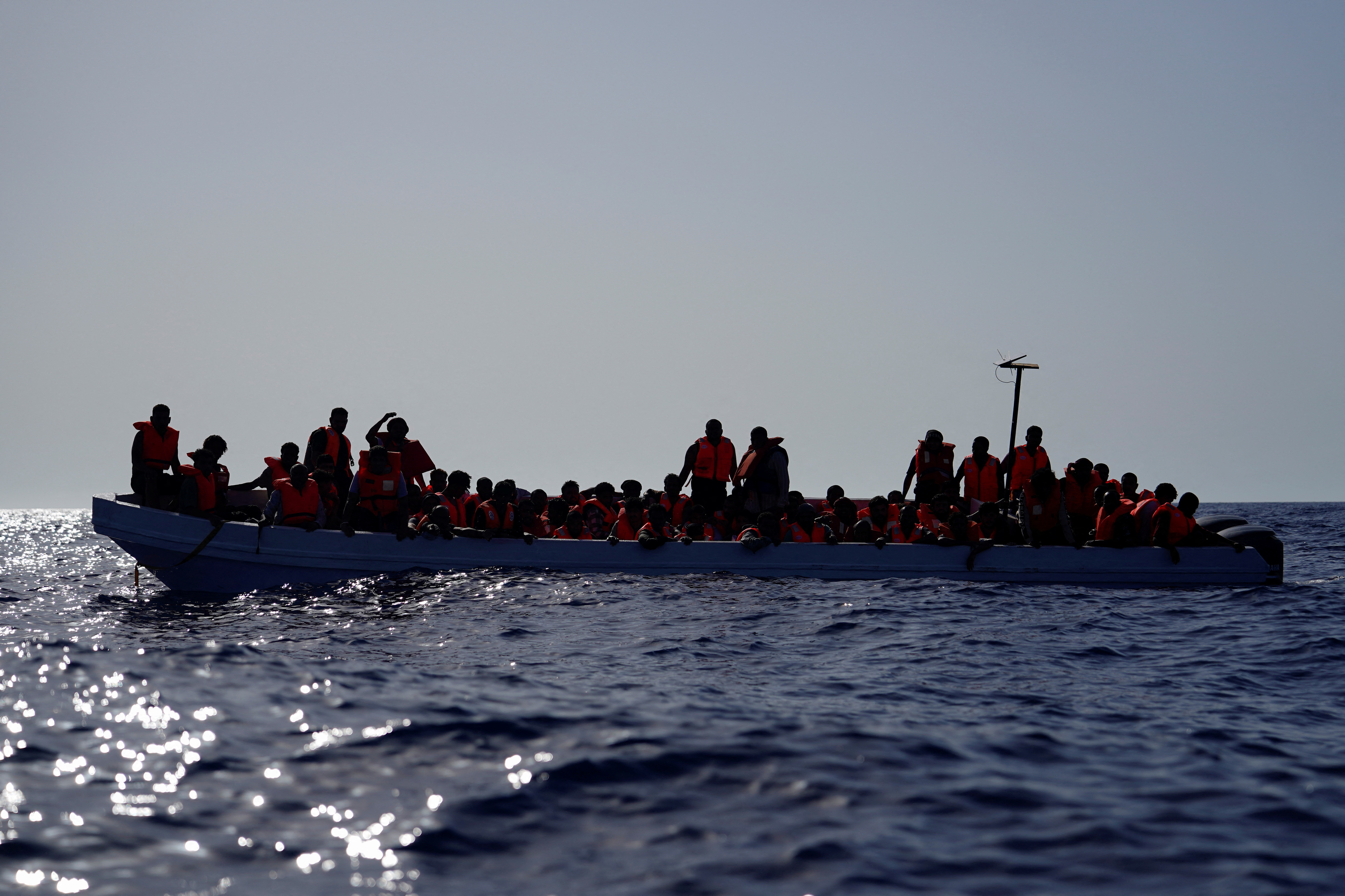 Migrants on a fiberglass boat wait to be assisted by NGO Open Arms rescue boat “Astral” lifeguards in international waters south of Lampedusa, in the Mediterranean Sea, July 24, 2025. REUTERS/Ana Beltran