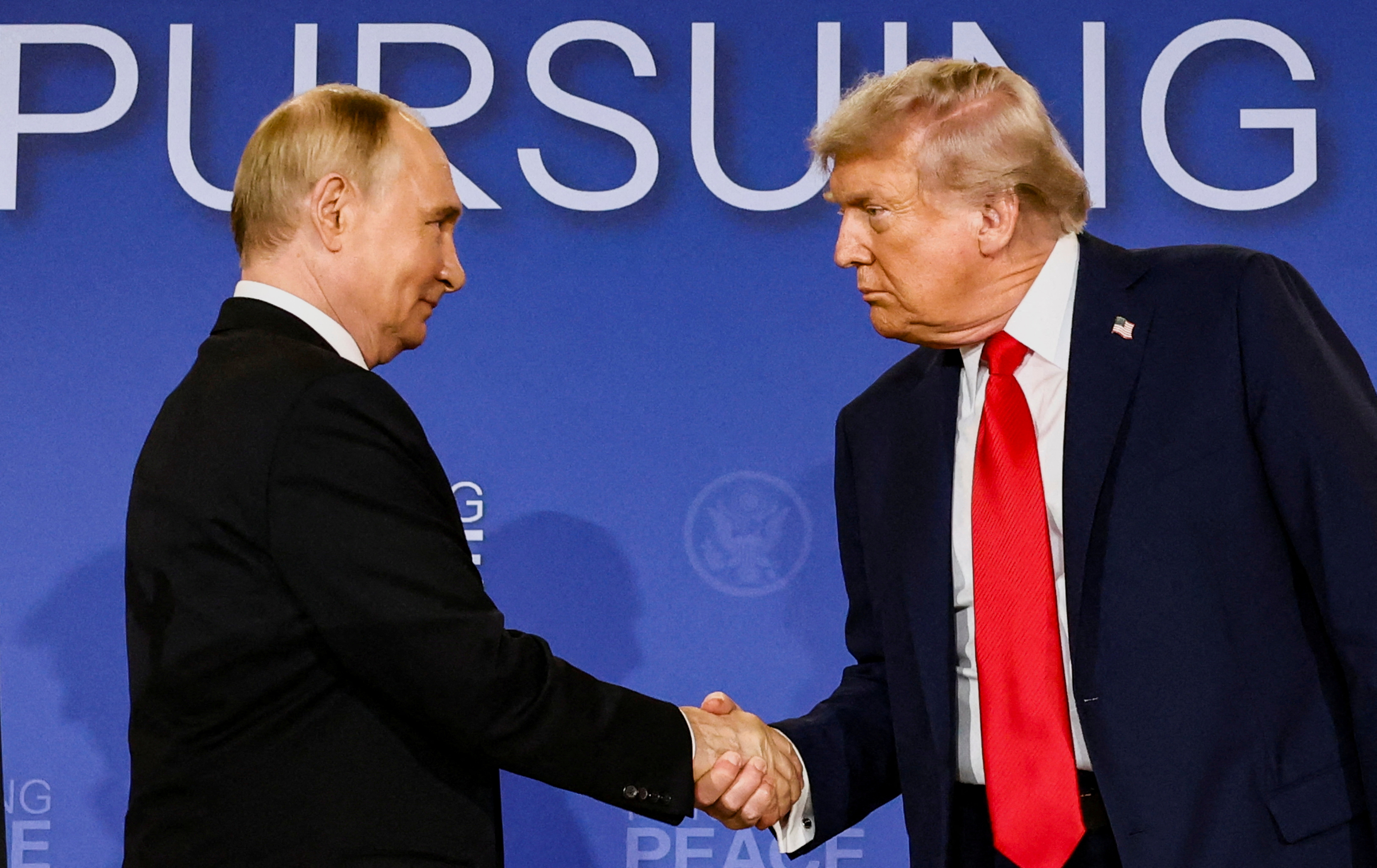 FILE PHOTO: U.S. President Donald Trump and Russian President Vladimir Putin shake hands during a press conference