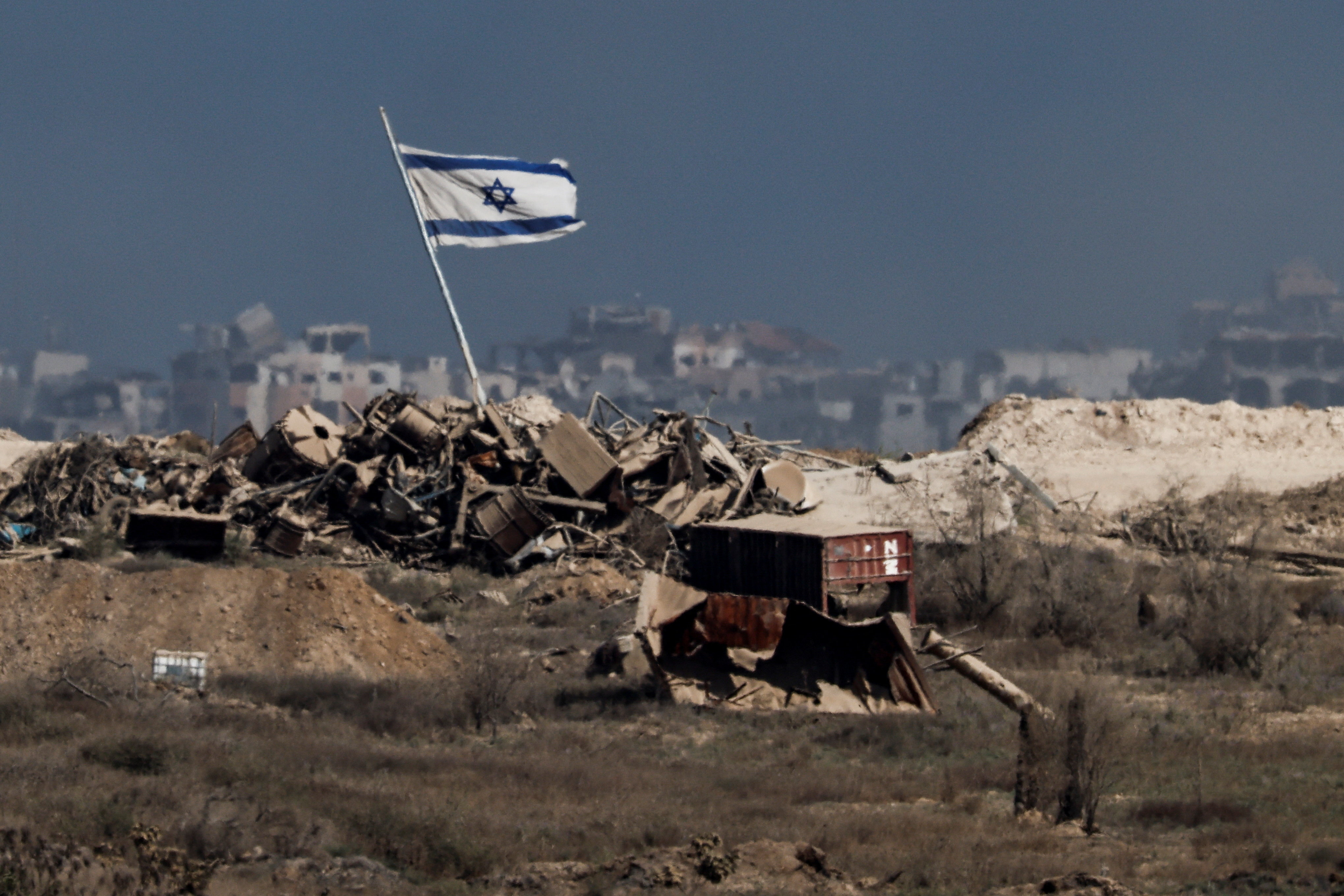 An Israeli flag flutters in Gaza, as seen from the Israeli side of the border with Gaza