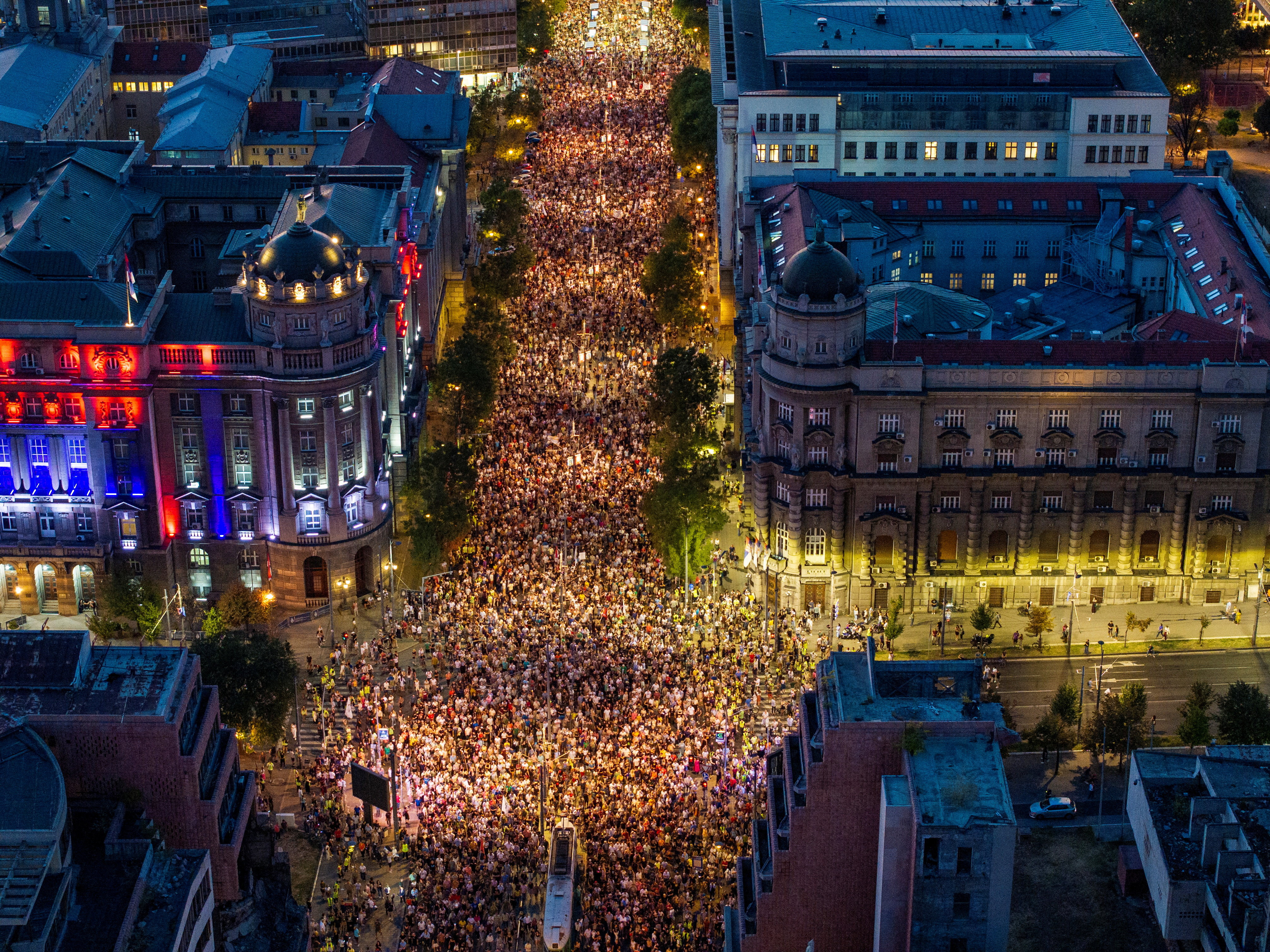 A drone view shows anti-government protestors marching through the streets to comme