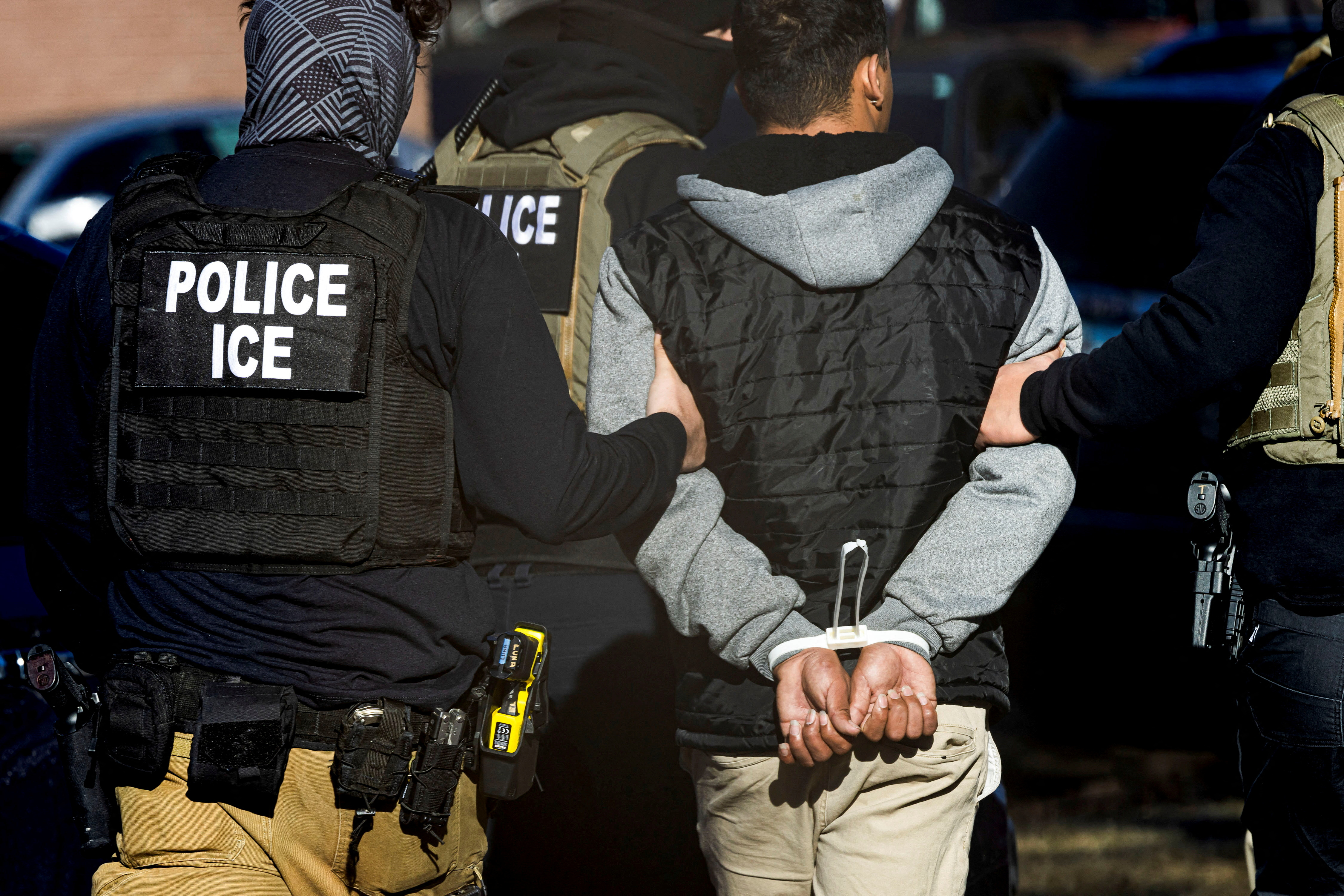 FILE PHOTO: Immigration and Customs Enforcement agents detain a man after conducting a raid at the Cedar Run apartment complex in Denver, Colorado, U.S., February 5, 2025. REUTERS/Kevin Mohatt/File Photo