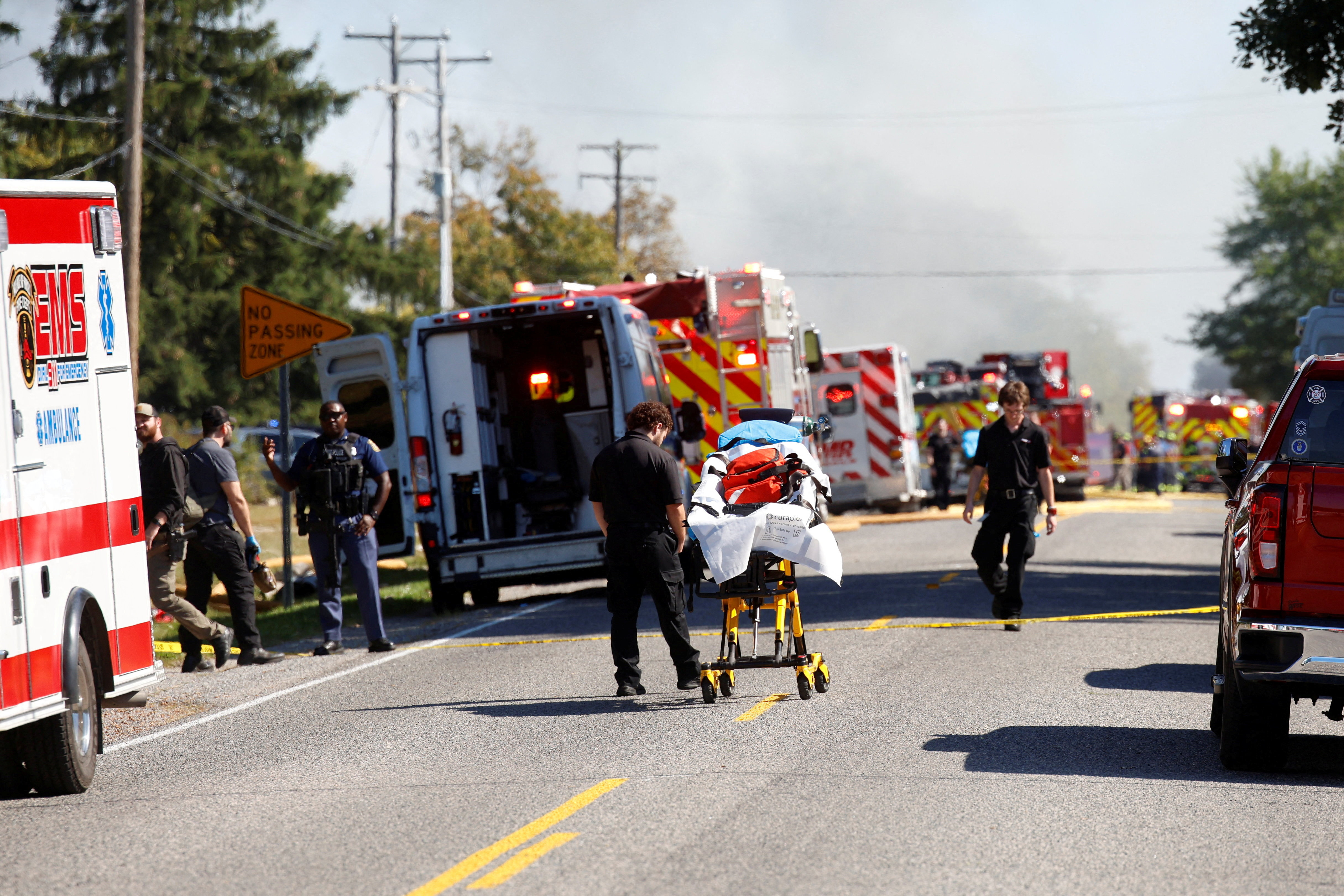 Smoke rises as members of emergency personnel work at the scene of a shooting