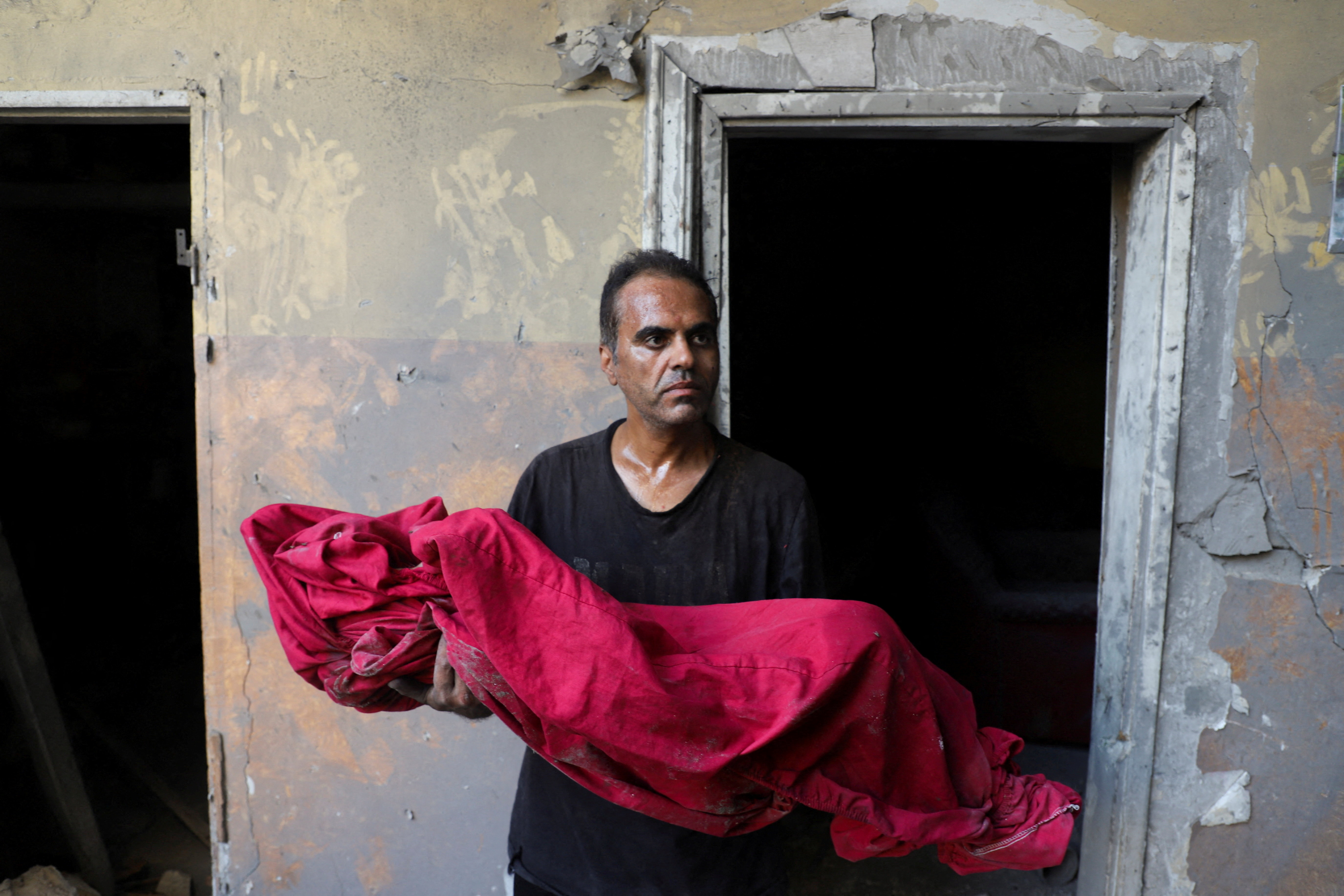 Palestinian father Shadi Mansour carries the body of his son Ameer, who was killed in an Israeli strike on a house on Saturday in the Tuffah neighborhood in Gaza City, October 5, 2025. REUTERS/Ebrahim Hajjaj     TPX IMAGES OF THE DAY
