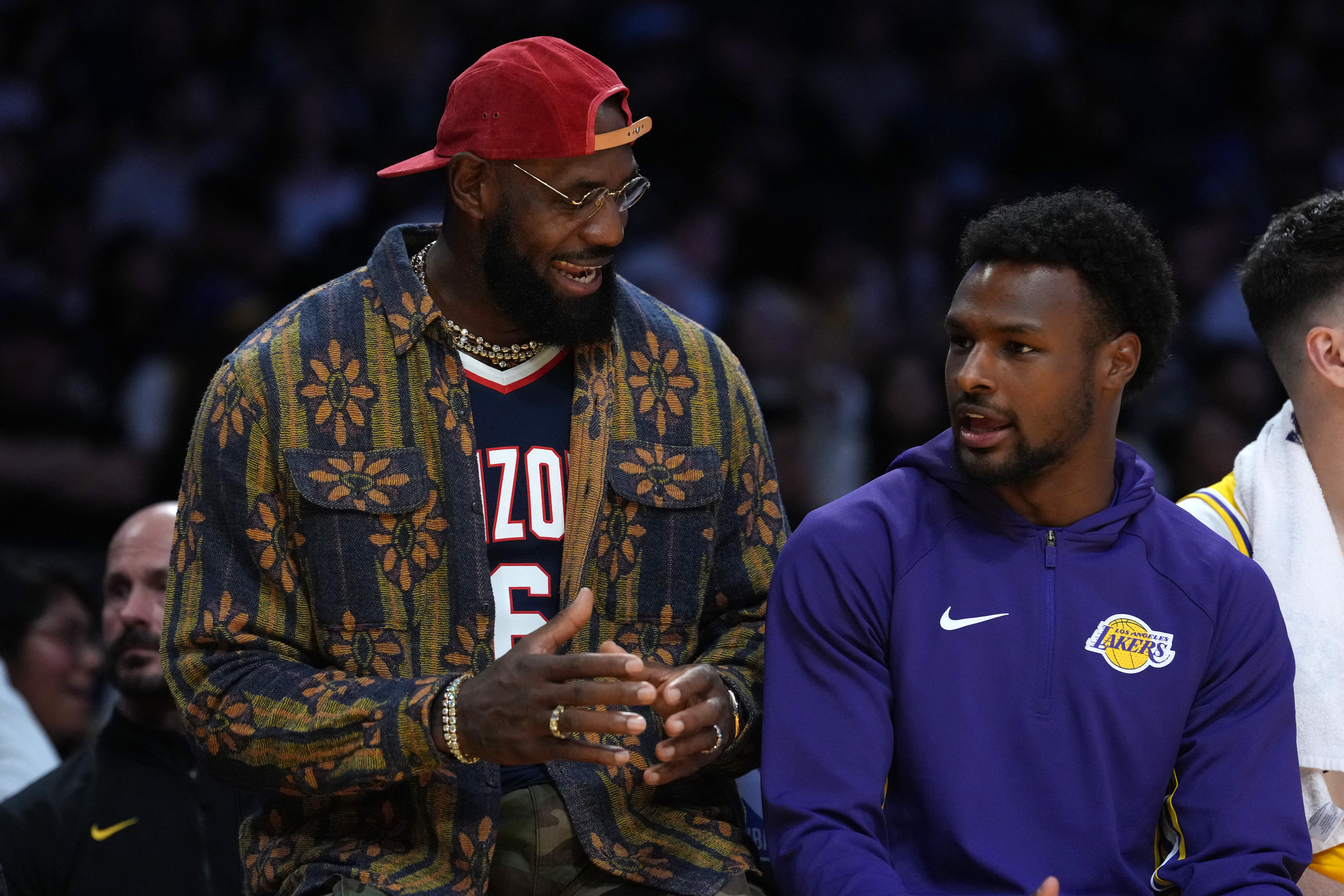 Oct 24, 2025; Los Angeles, California, USA; Los Angeles Lakers forward LeBron James (left) and son Bronny James  watch from the bench in the second half against the Minnesota Timberwolves at Crypto.com Arena. Mandatory Credit: Kirby Lee-Imagn Images