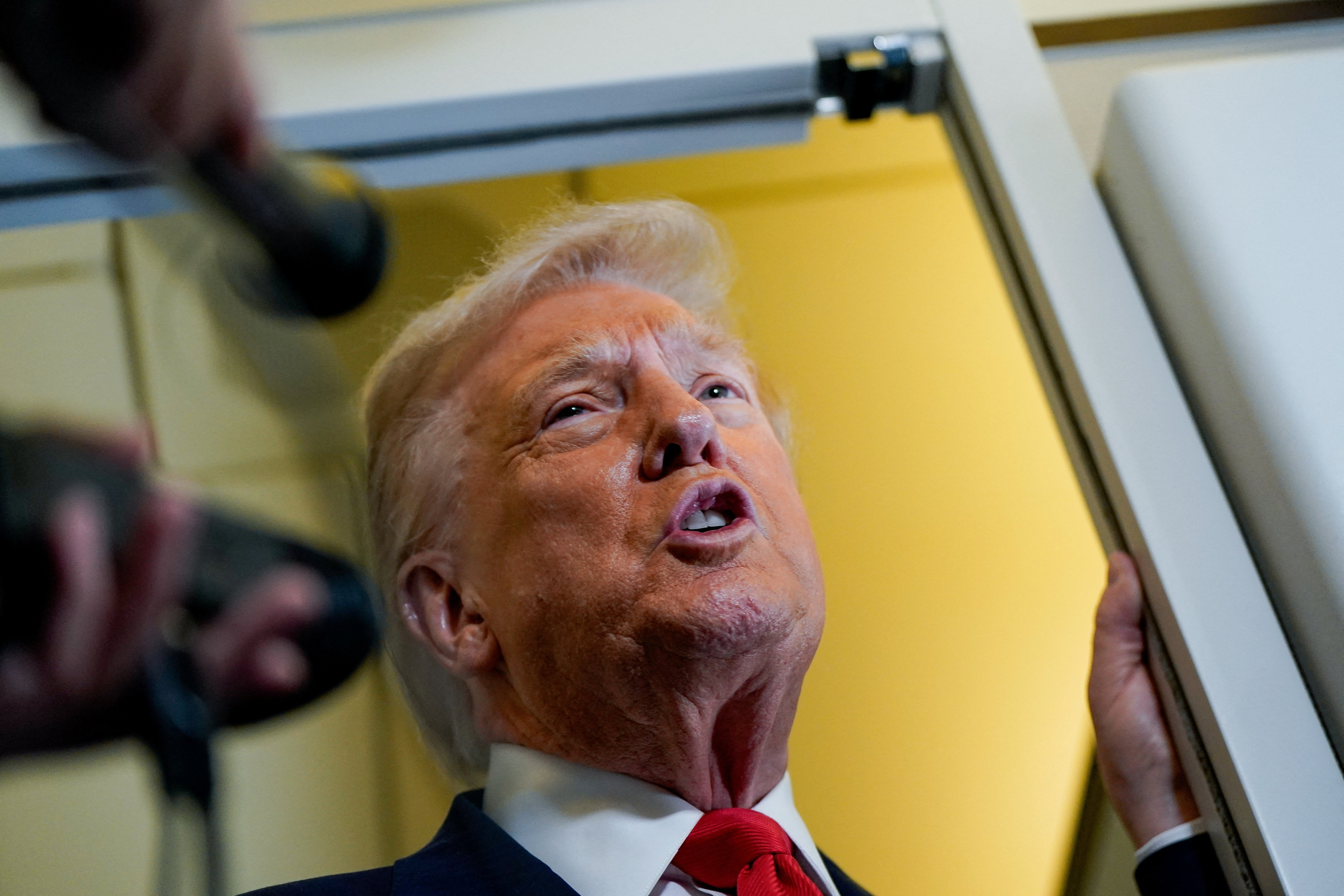 U.S. President Donald Trump speaks to members of the media aboard
