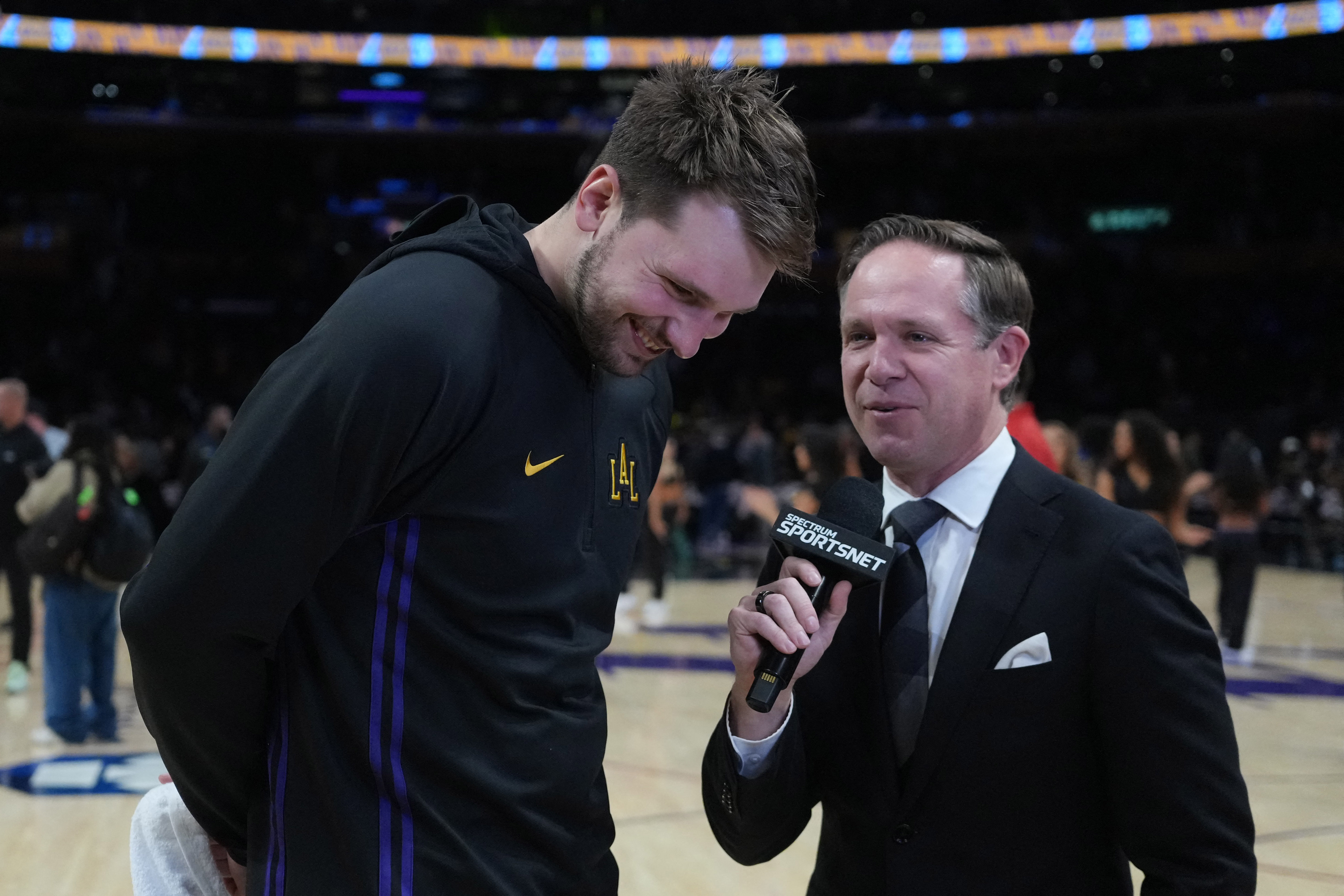 Nov 18, 2025; Los Angeles, California, USA; Los Angeles Lakers guard Luka Doncic (left) is interviewed by Spectrum SportsNet reporter Mike Trudell after the game against the Utah Jazz at Crypto.com Arena. Mandatory Credit: Kirby Lee-Imagn Images