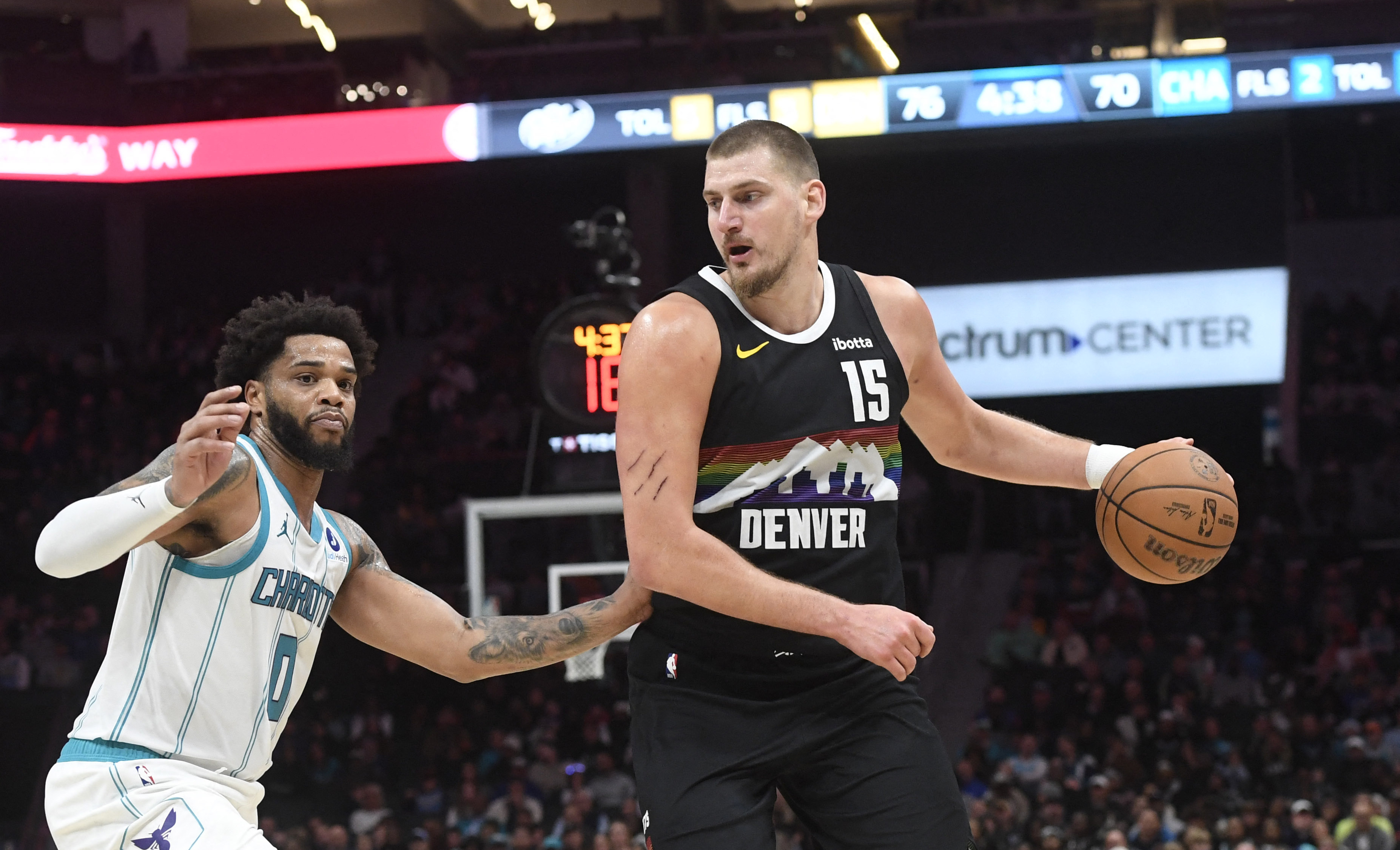 Dec 7, 2025; Charlotte, North Carolina, USA; Denver Nuggets center Nikola Jokic (15) looks to drive past Charlotte Hornets forward Miles Bridges (0) during the second half at the Spectrum Center. Mandatory Credit: Sam Sharpe-Imagn Images