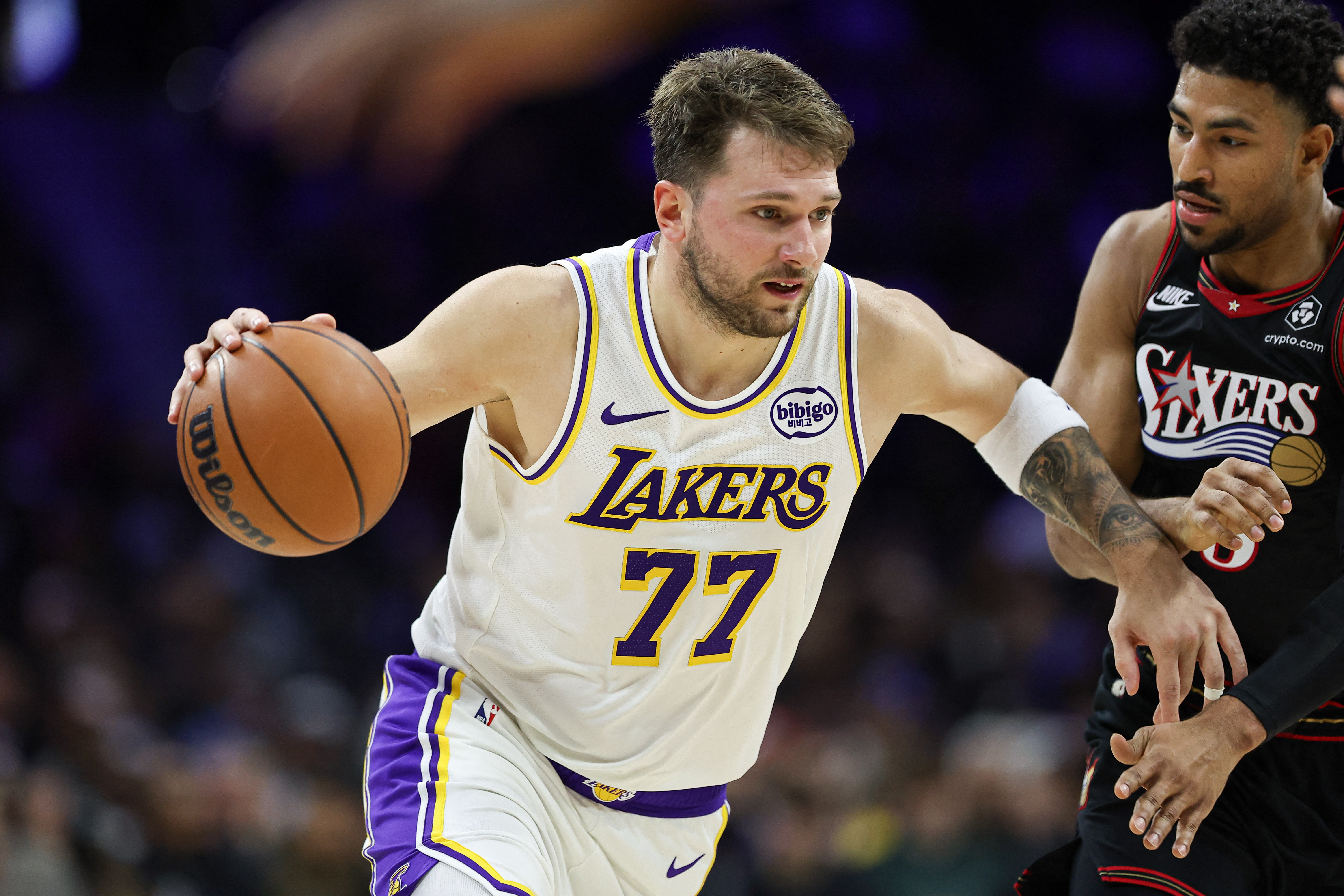 Dec 7, 2025; Philadelphia, Pennsylvania, USA; Los Angeles Lakers guard Luka Doncic (77) drives against Philadelphia 76ers guard Quentin Grimes (5) during the second quarter at Xfinity Mobile Arena. Mandatory Credit: Bill Streicher-Imagn Images