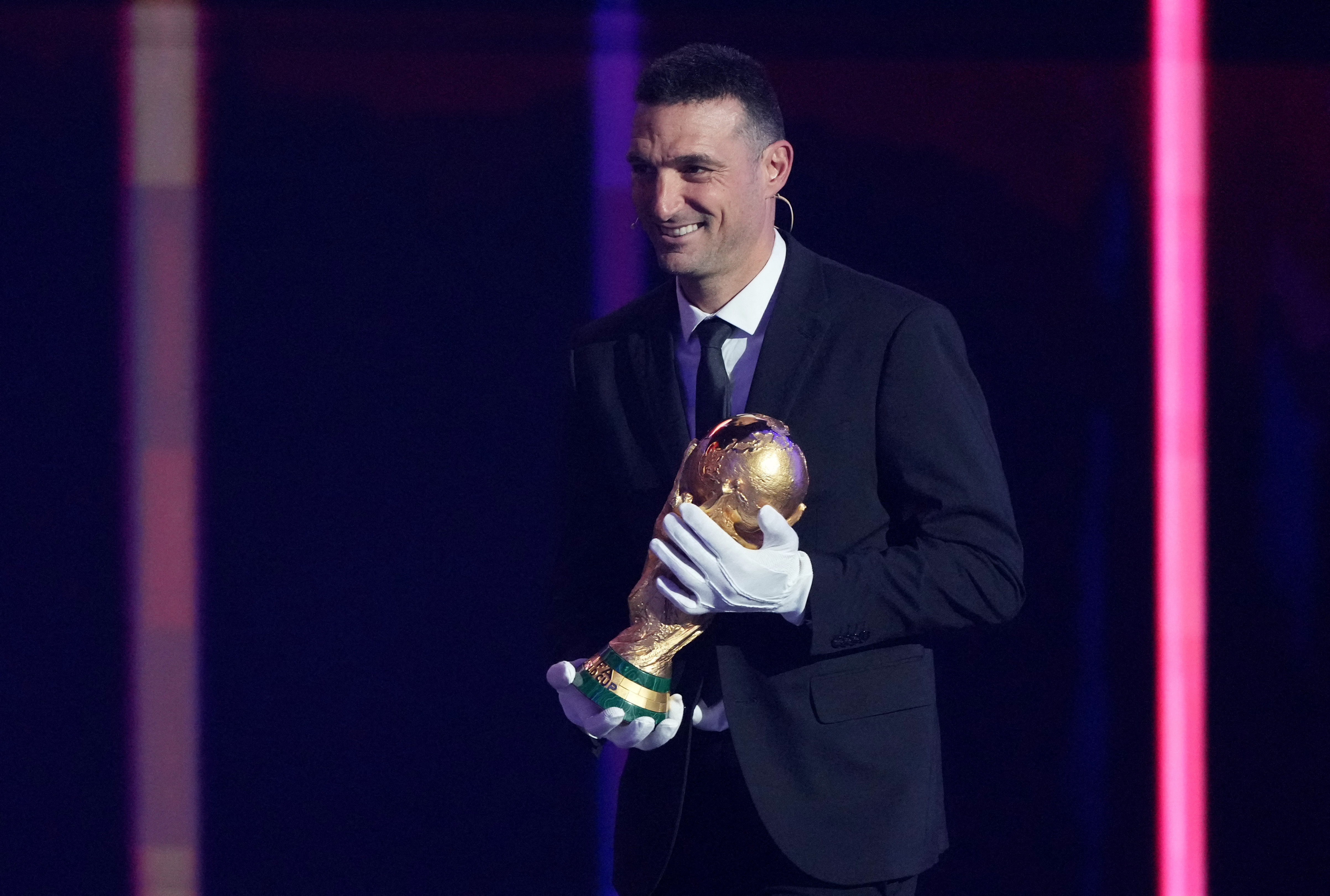 Soccer Football - FIFA World Cup 2026 - FIFA World Cup 2026 Draw - John F. Kennedy Center for the Performing Arts, Washington, D.C., U.S. - December 5, 2025 Argentina coach Lionel Scaloni brings the World Cup trophy onto stage during the FIFA World Cup 20
