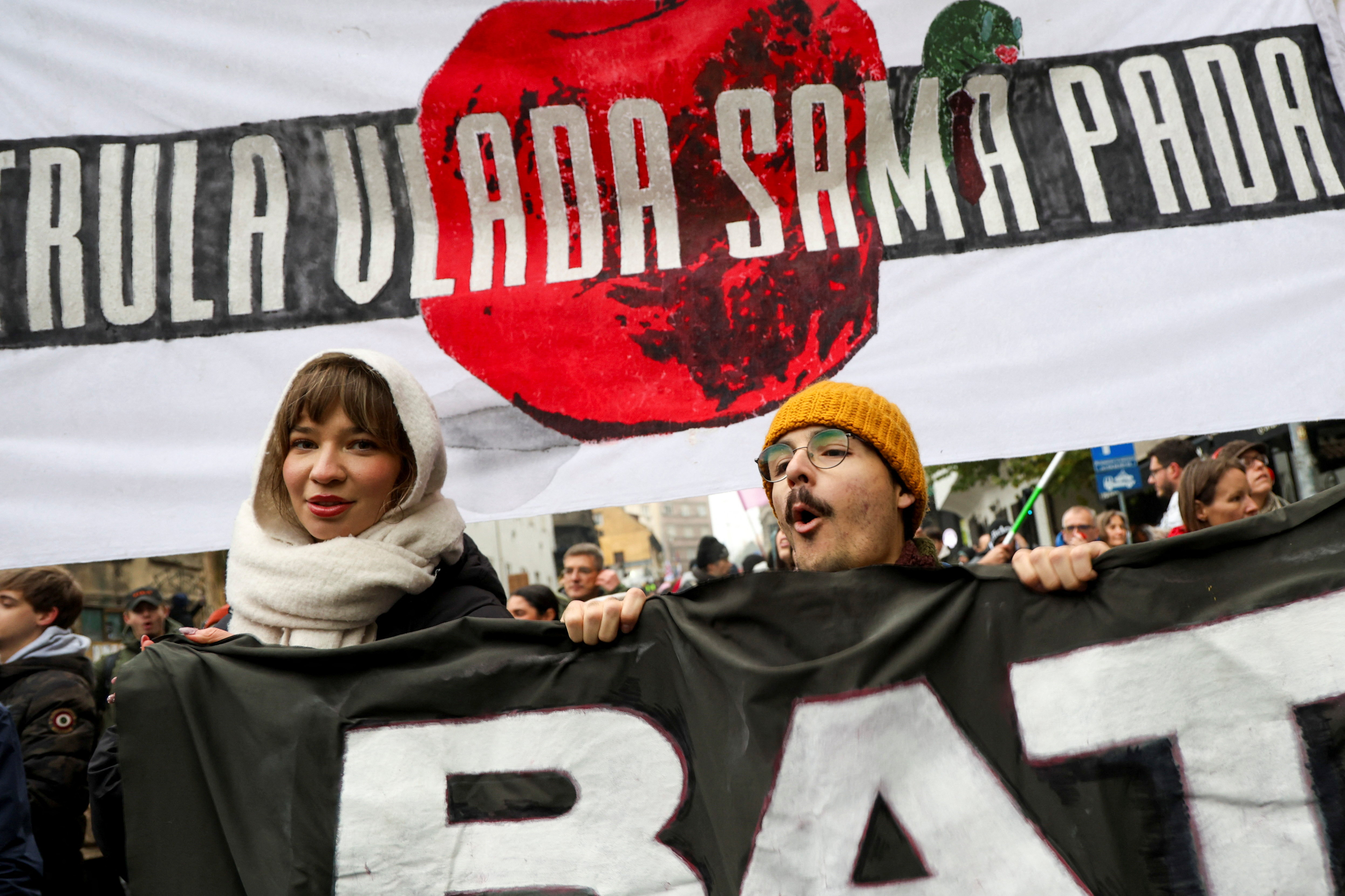 Students and citizens shout slogans while marching along a street