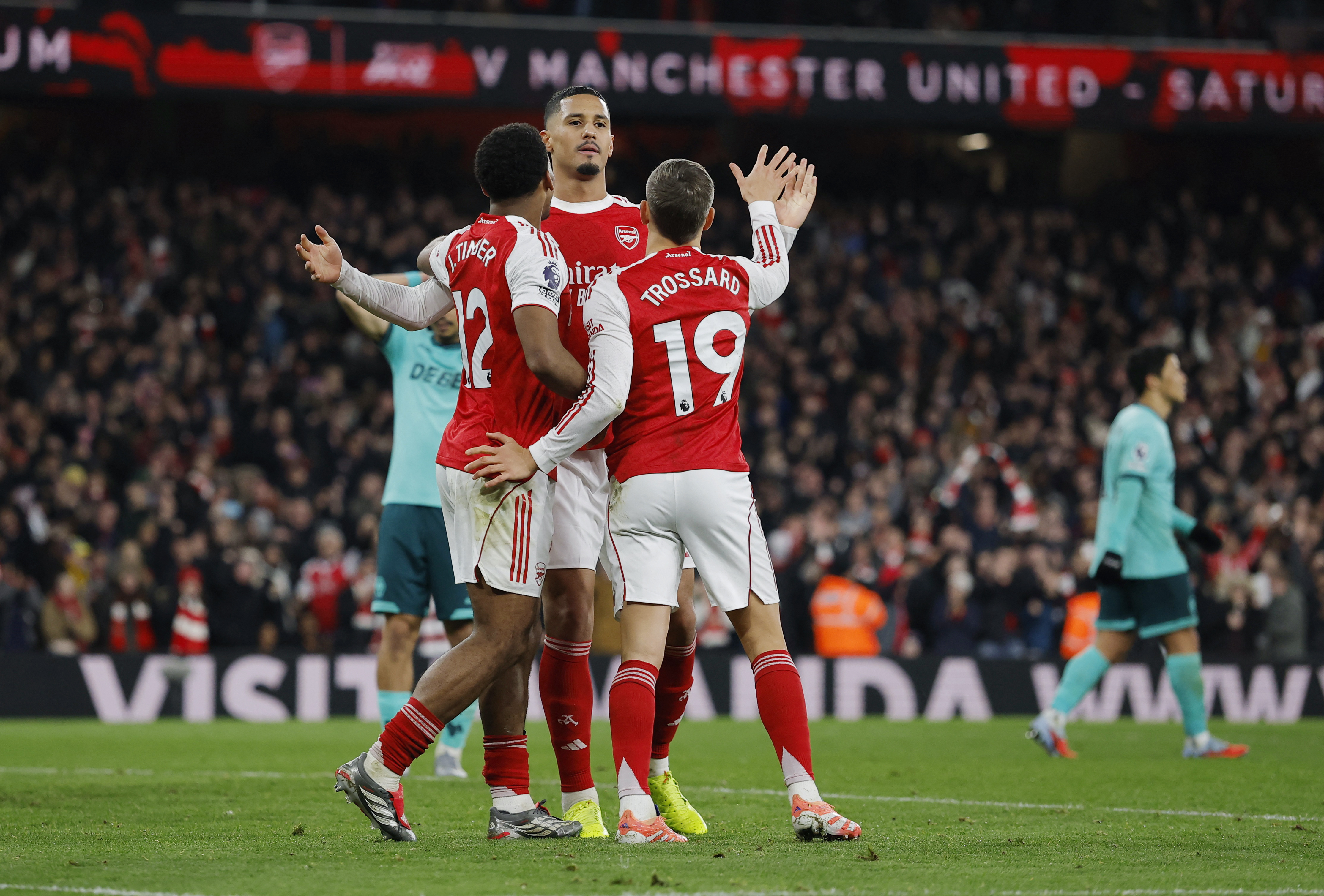 Soccer Football - Premier League - Arsenal v Wolverhampton Wanderers - Emirates Stadium, London, Britain - December 13, 2025 Arsenal's Jurrien Timber, William Saliba and Leandro Trossard celebrate their first goal, an own goal scored by Wolverhampton Wand