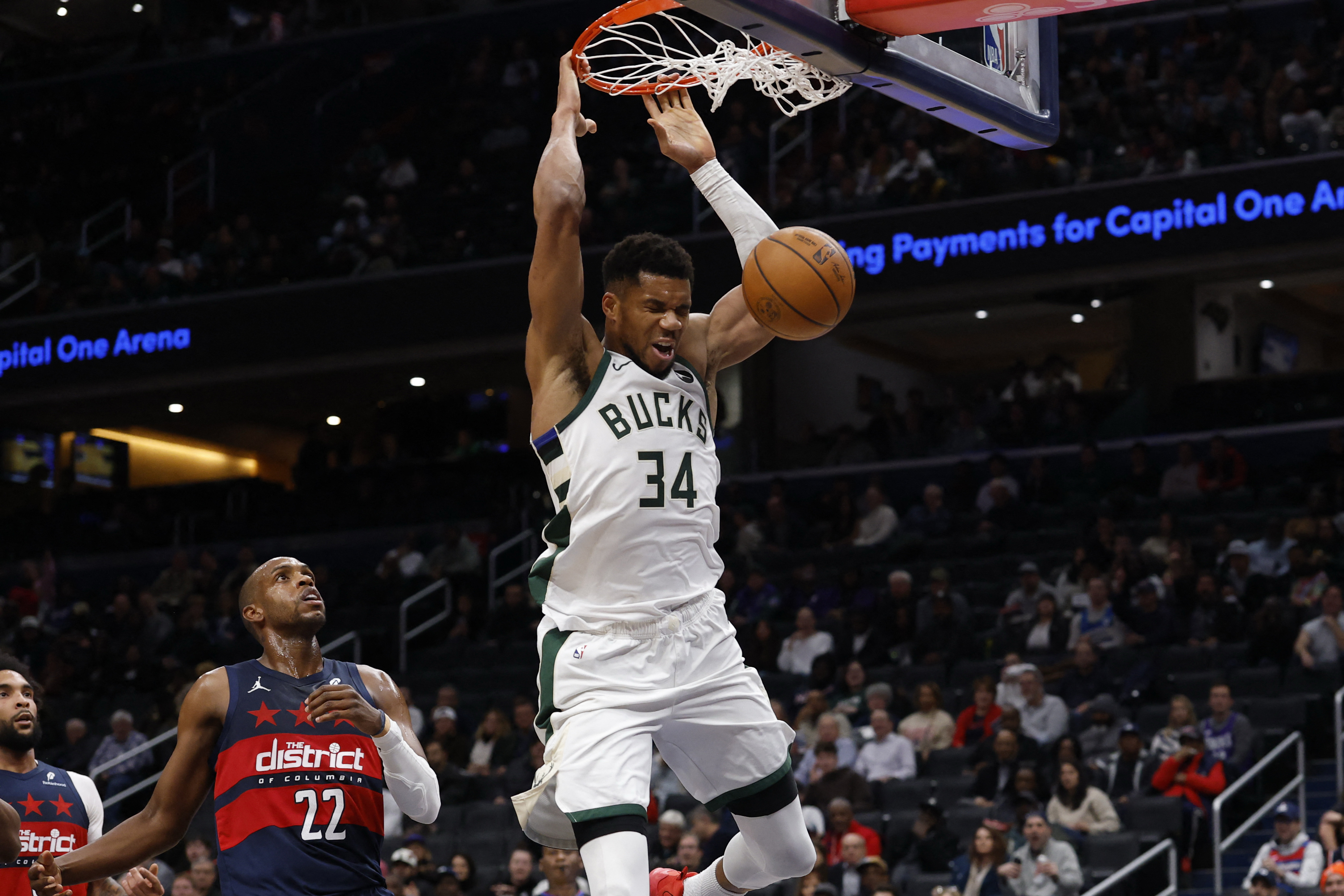 Dec 1, 2025; Washington, District of Columbia, USA; Milwaukee Bucks forward Giannis Antetokounmpo (34) dunks the ball as Washington Wizards forward Khris Middleton (22) looks on in the second quarter at Capital One Arena. Mandatory Credit: Geoff Burke-Ima