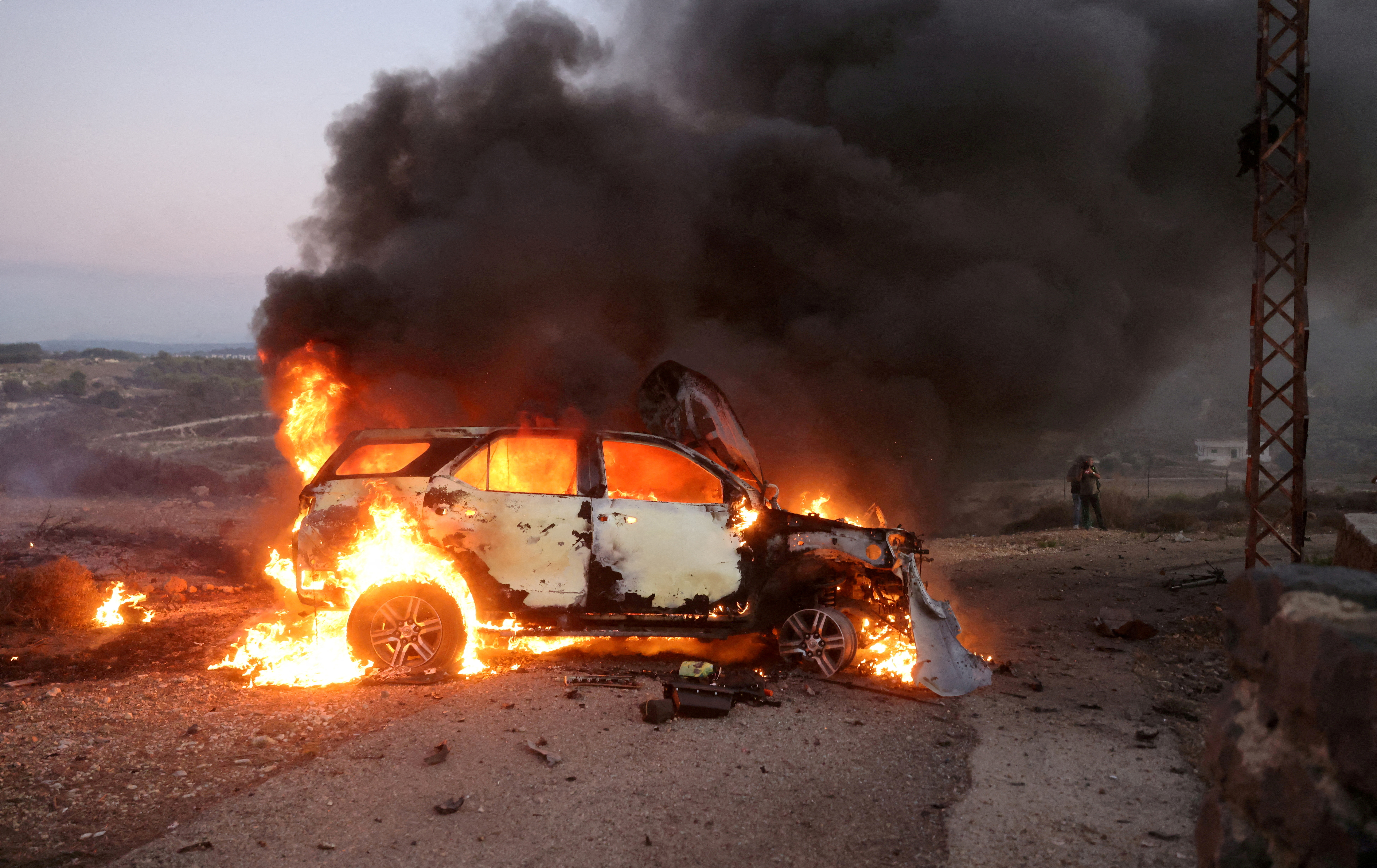 FILE PHOTO: A car belonging to an Al Jazeera team burns