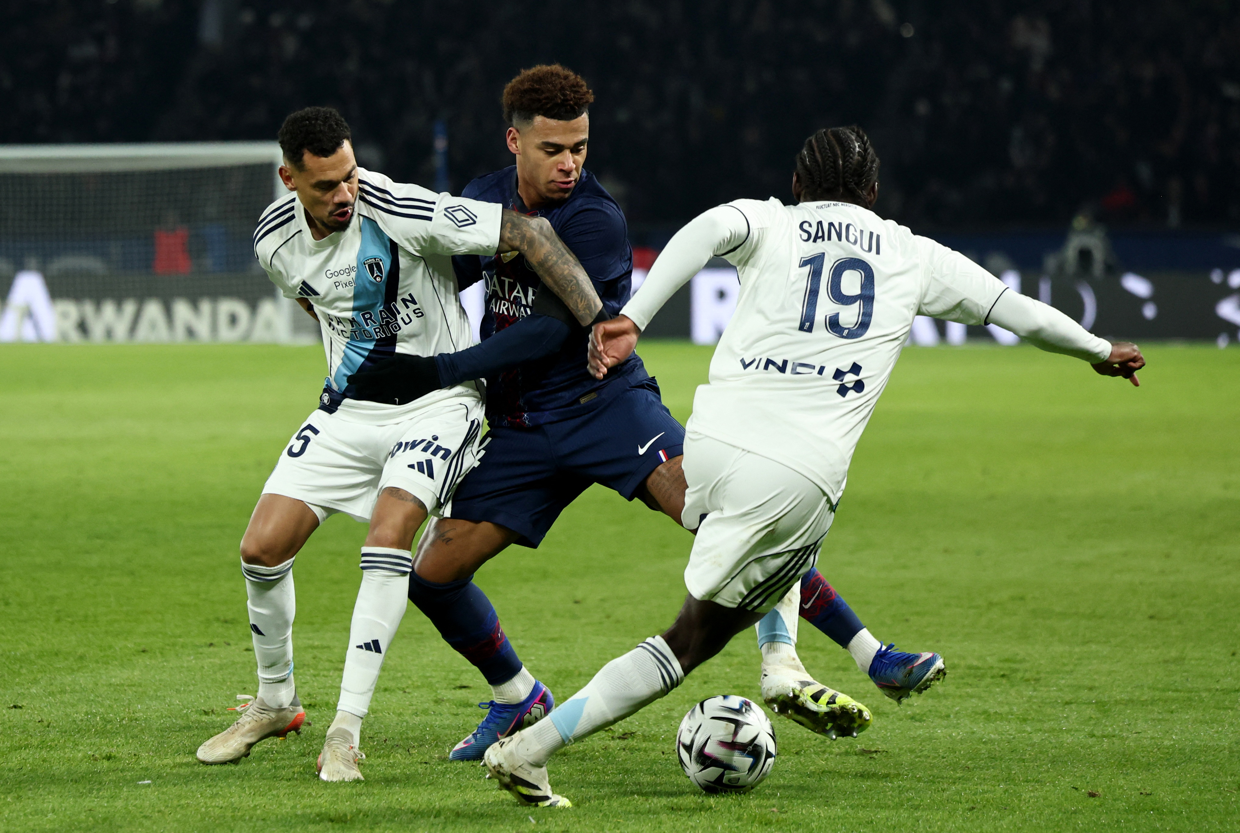 Soccer Football - Ligue 1 - Paris St Germain v Paris FC - Parc des Princes, Paris, France - January 4, 2026 Paris St Germain's Desire Doue in action with Paris FC's Timothee Kolodziejczak and Nhoa Sangui REUTERS/Catherine Steenkeste