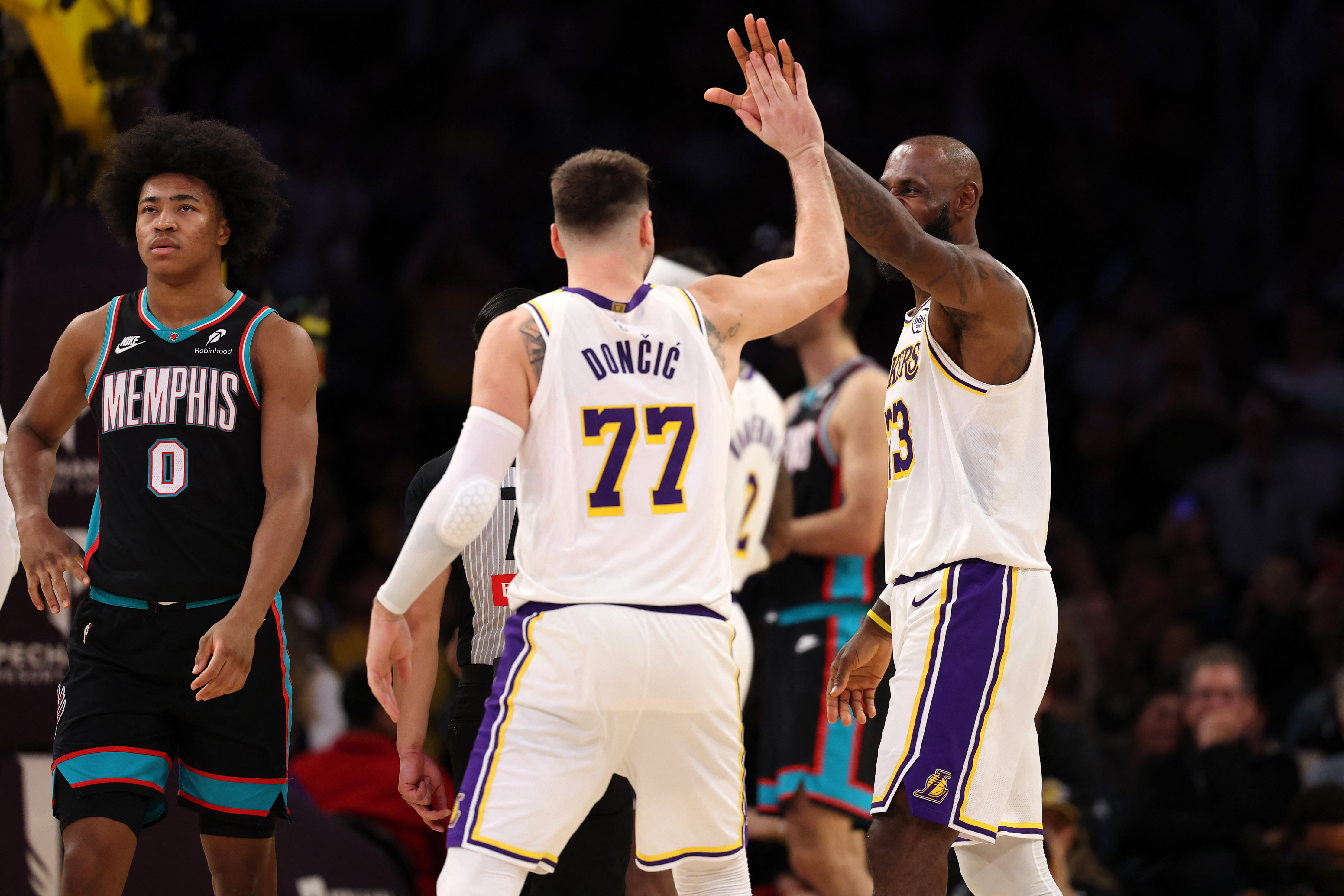 Jan 4, 2026; Los Angeles, California, USA;  Los Angeles Lakers forward LeBron James (right) is greeted by forward Luka Doncic (77) after making a basket during the fourth quarter against the Memphis Grizzlies at Crypto.com Arena. Mandatory Credit: Kiyoshi