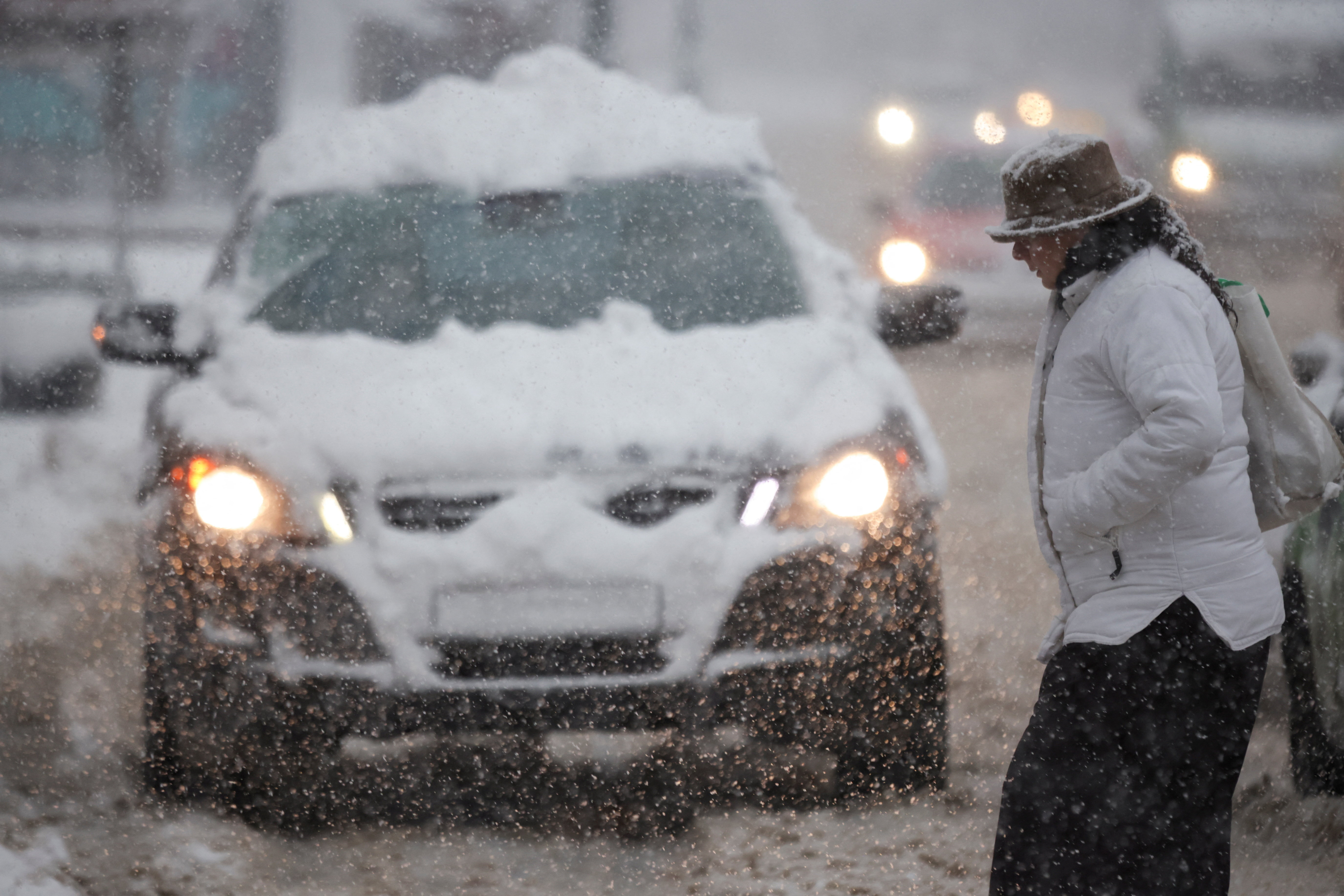 A woman crosses the street during a snowstorm in Sarajevo, Bosnia and Herzegovina January 04, 2026. REUTERS/Amel Emric