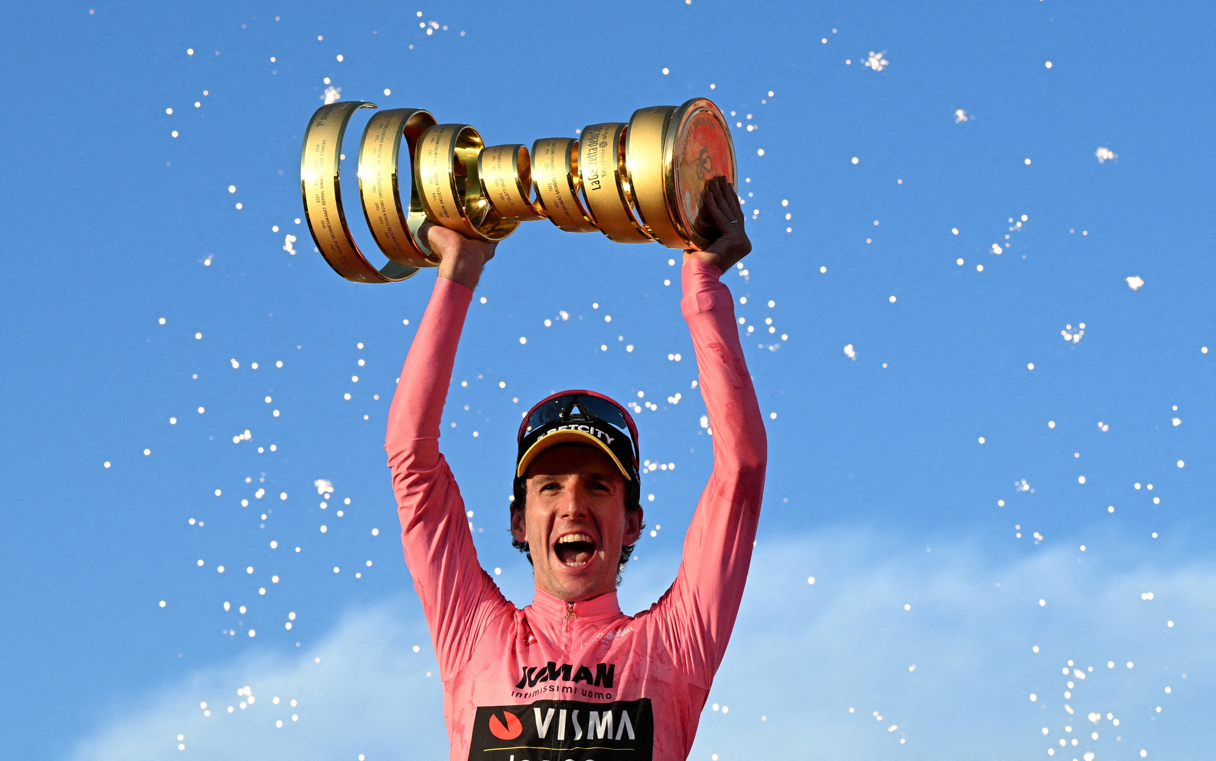 FILE PHOTO: Cycling - Giro d'Italia - Stage 21 - Rome to Rome - Italy - June 1, 2025 Team Visma | Lease a Bike's Simon Yates celebrates with a trophy on the podium after winning the Giro d'Italia REUTERS/Jennifer Lorenzini/File Photo