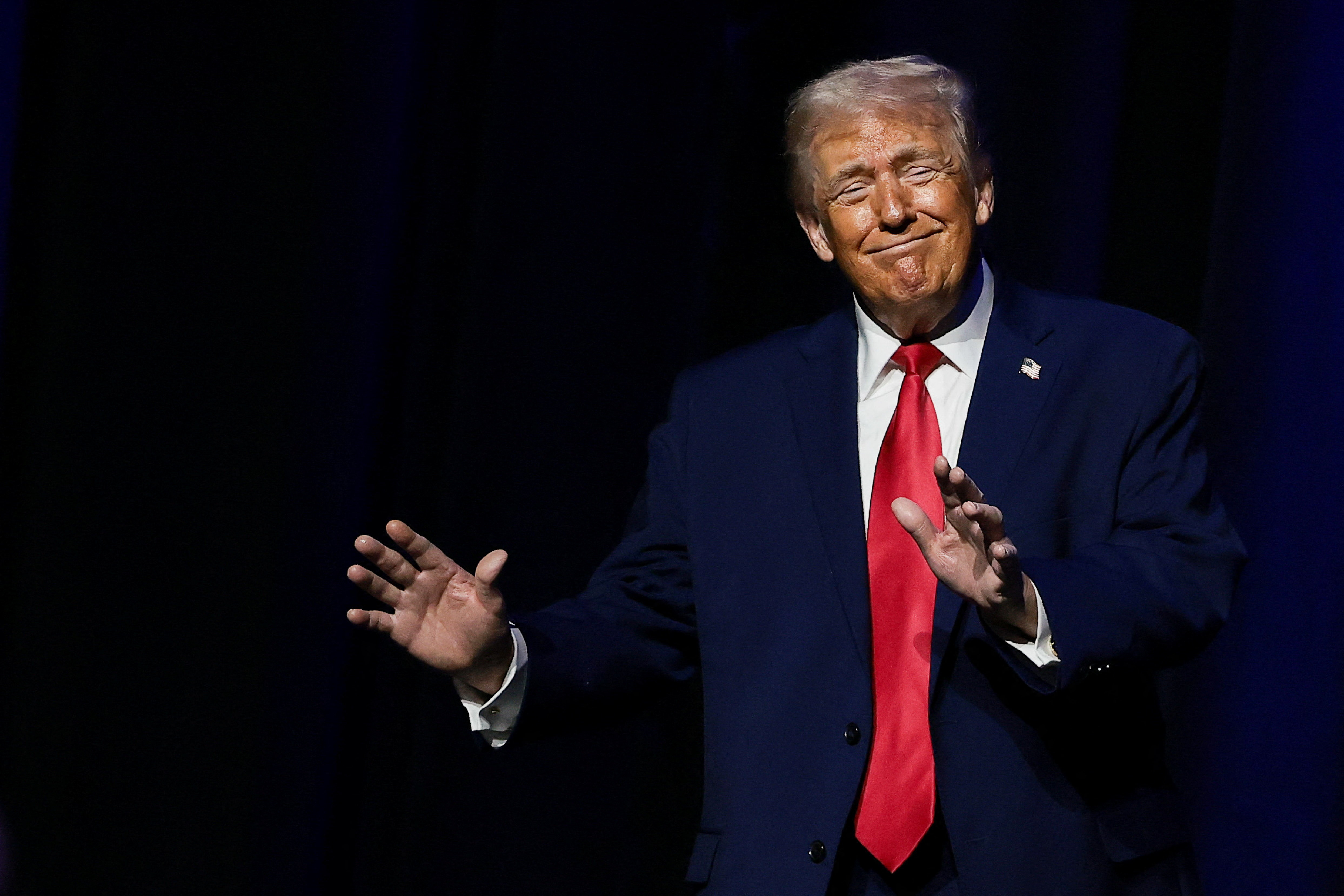 U.S. President Donald Trump gestures, at the Detroit Economic Club