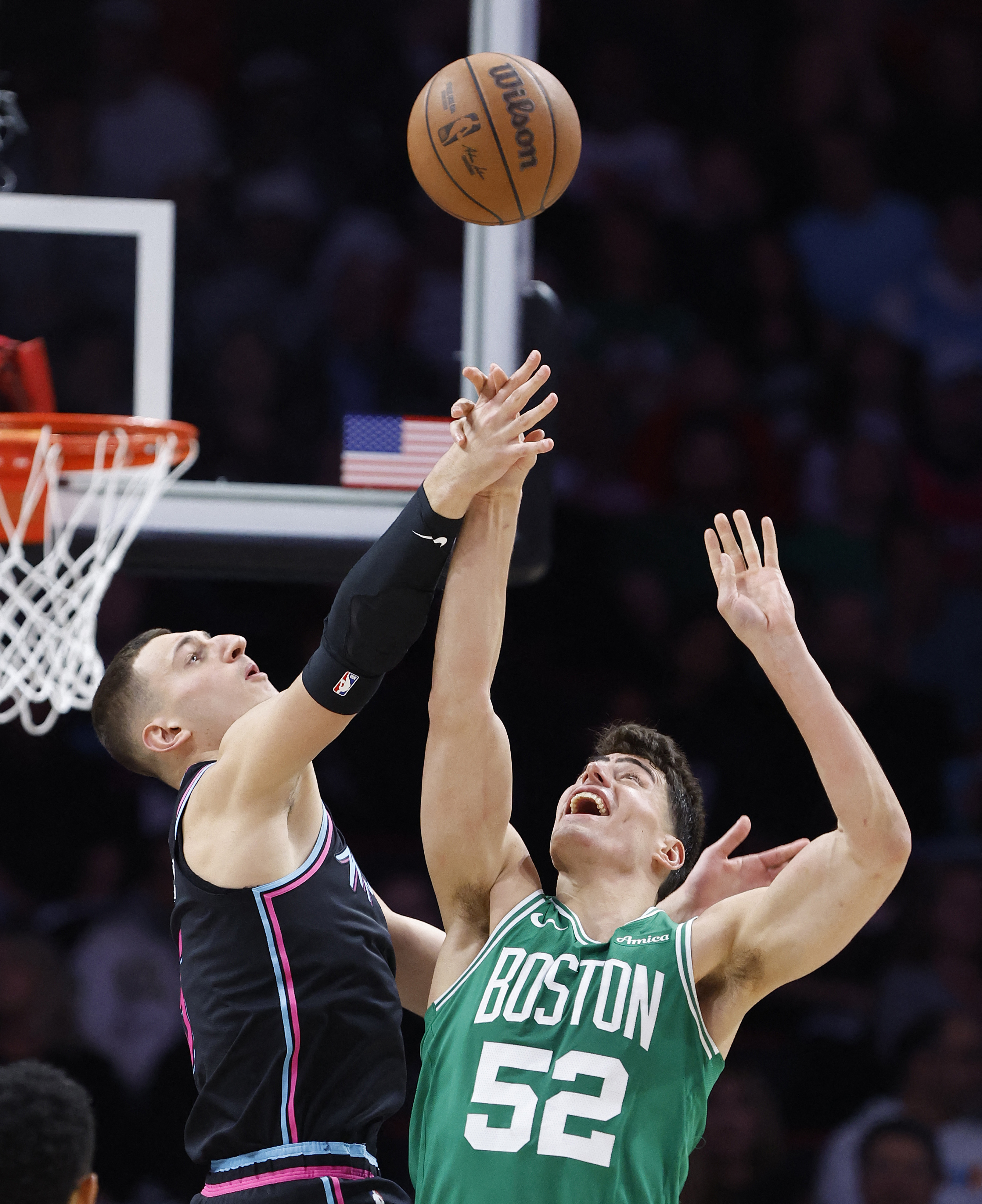 Jan 15, 2026; Miami, Florida, USA; Miami Heat forward Nikola Jovic (5) and Boston Celtics center Luka Garza (52) go after a rebound during the first half at Kaseya Center. Mandatory Credit: Rhona Wise-Imagn Images