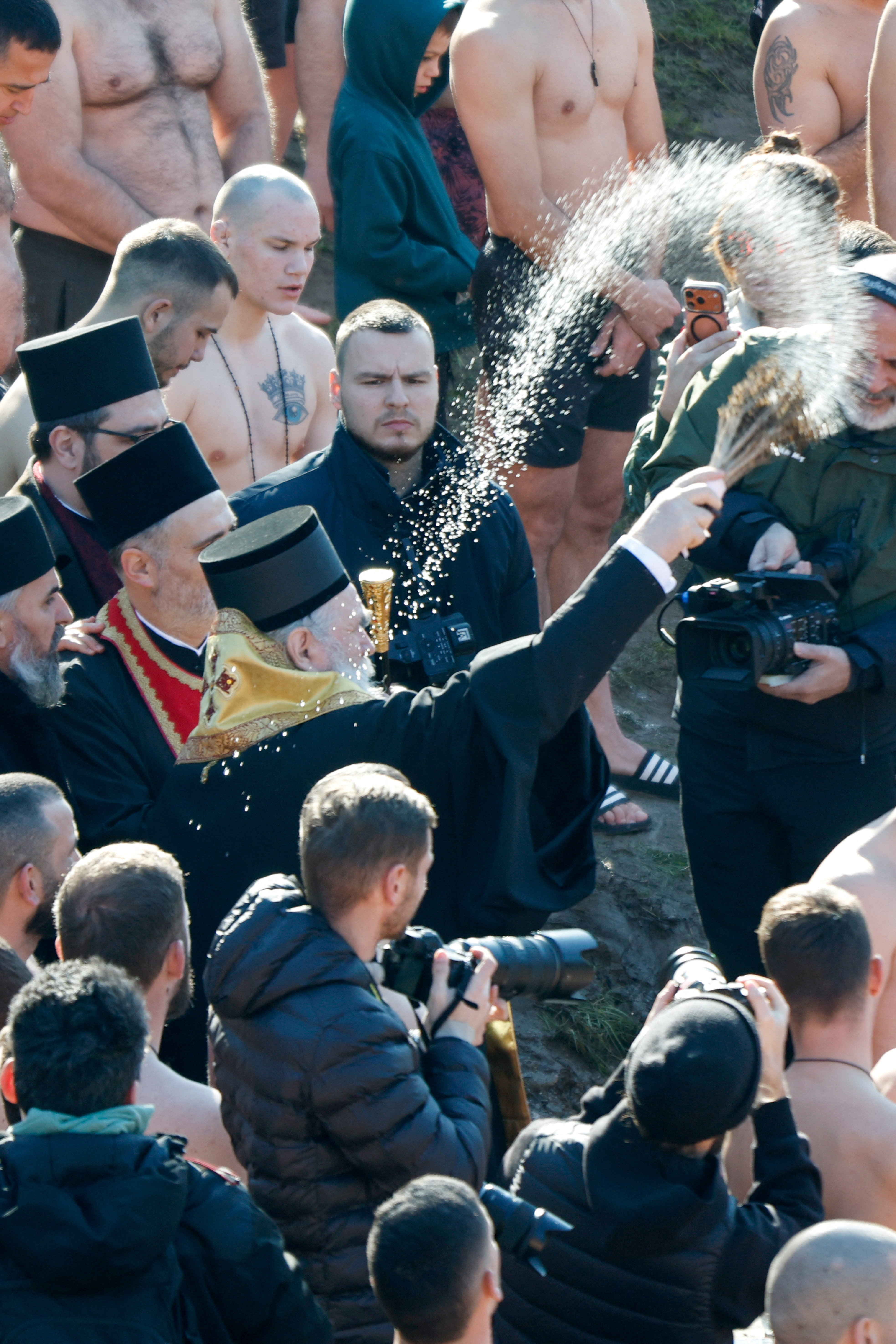A priest blesses the waters of the Moraca river before Orthodox Christians