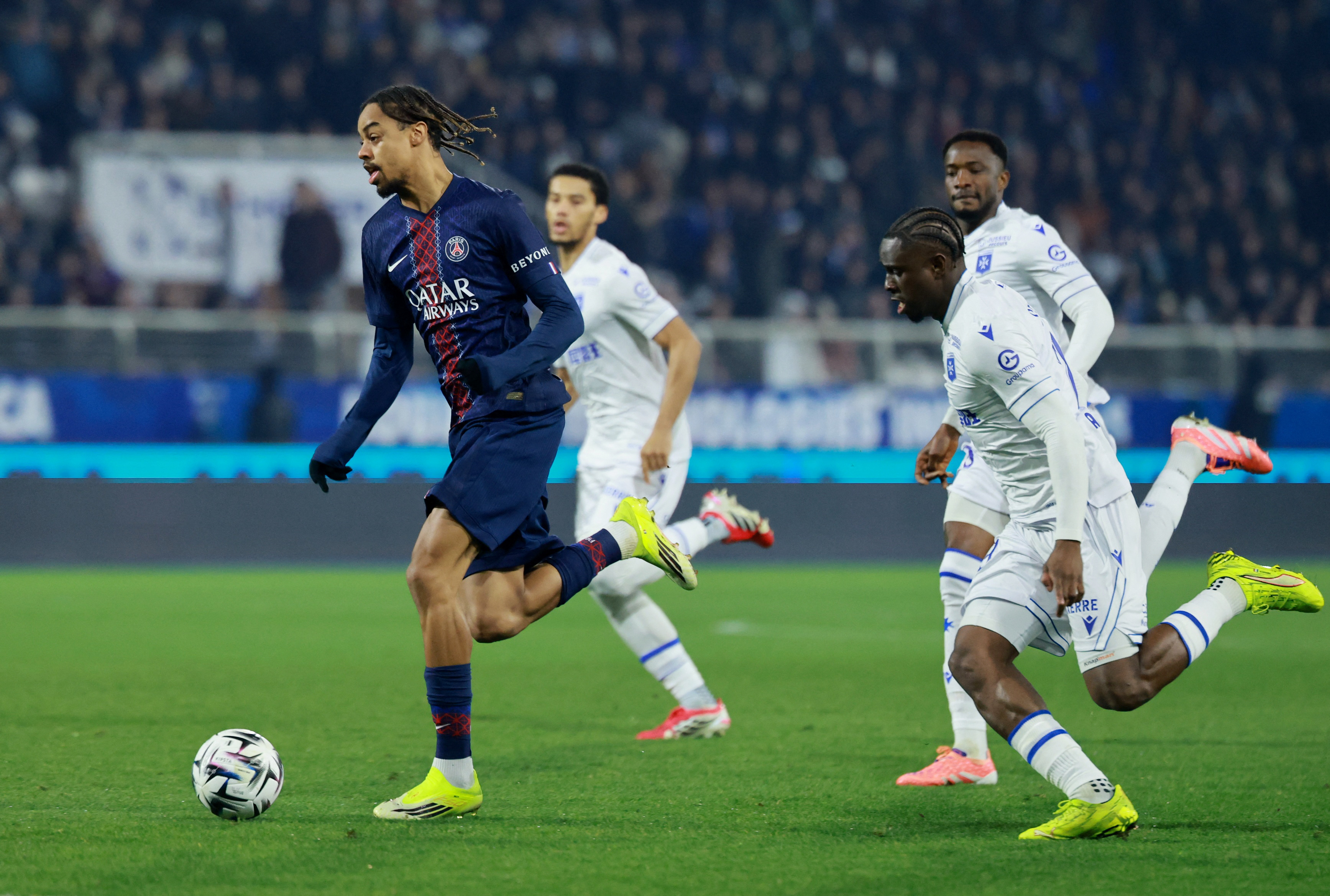 Soccer Football - Ligue 1 - AJ Auxerre v Paris St Germain - Stade de l'Abbe-Deschamps, Auxerre, France - January 23, 2026 Paris St Germain's Bradley Barcola in action with AJ Auxerre's Marvin Senaya REUTERS/Stephanie Lecocq