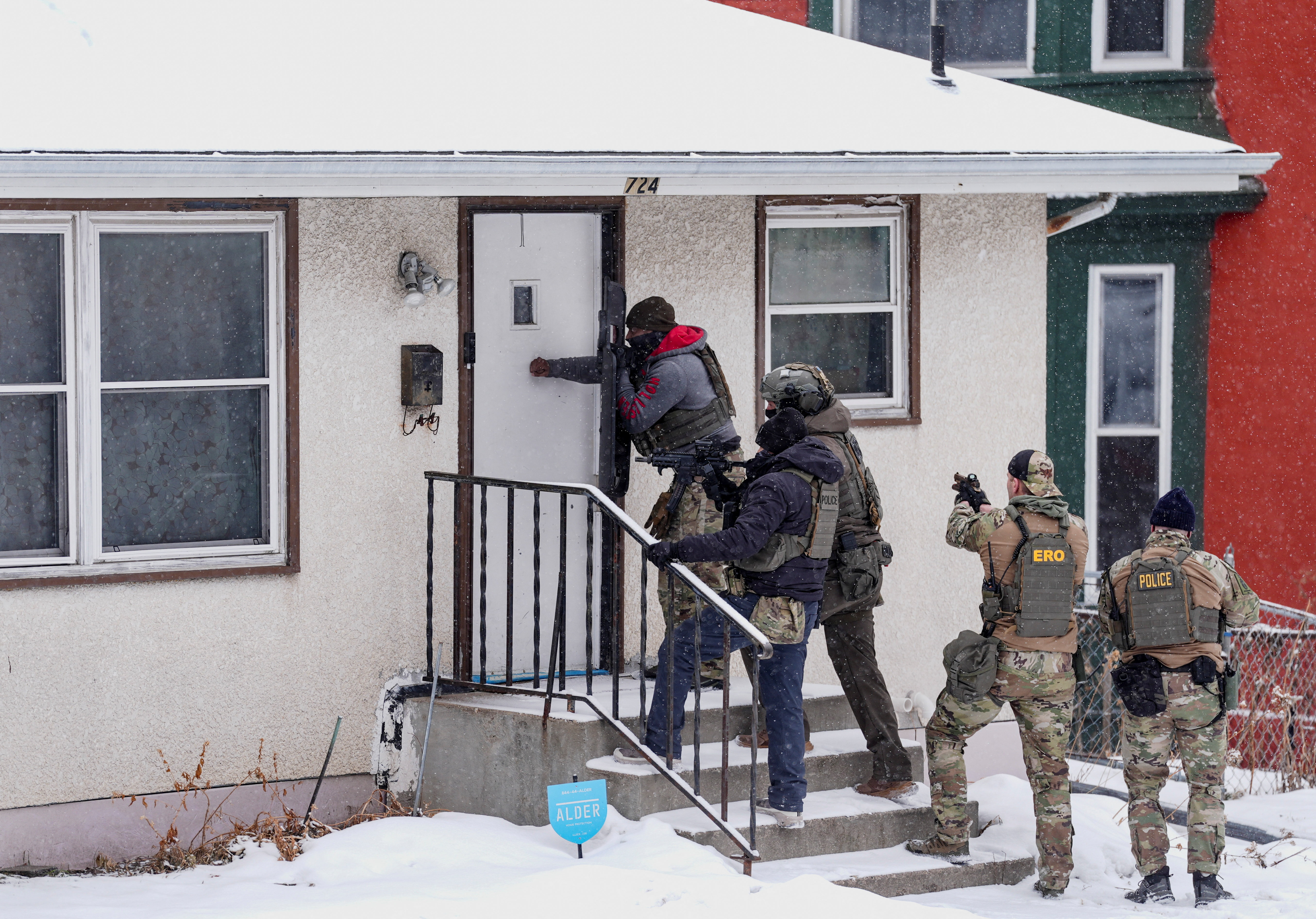 ICE agents and other law enforcement officers conduct an immigration raid at a home in St. Paul, Minnesota