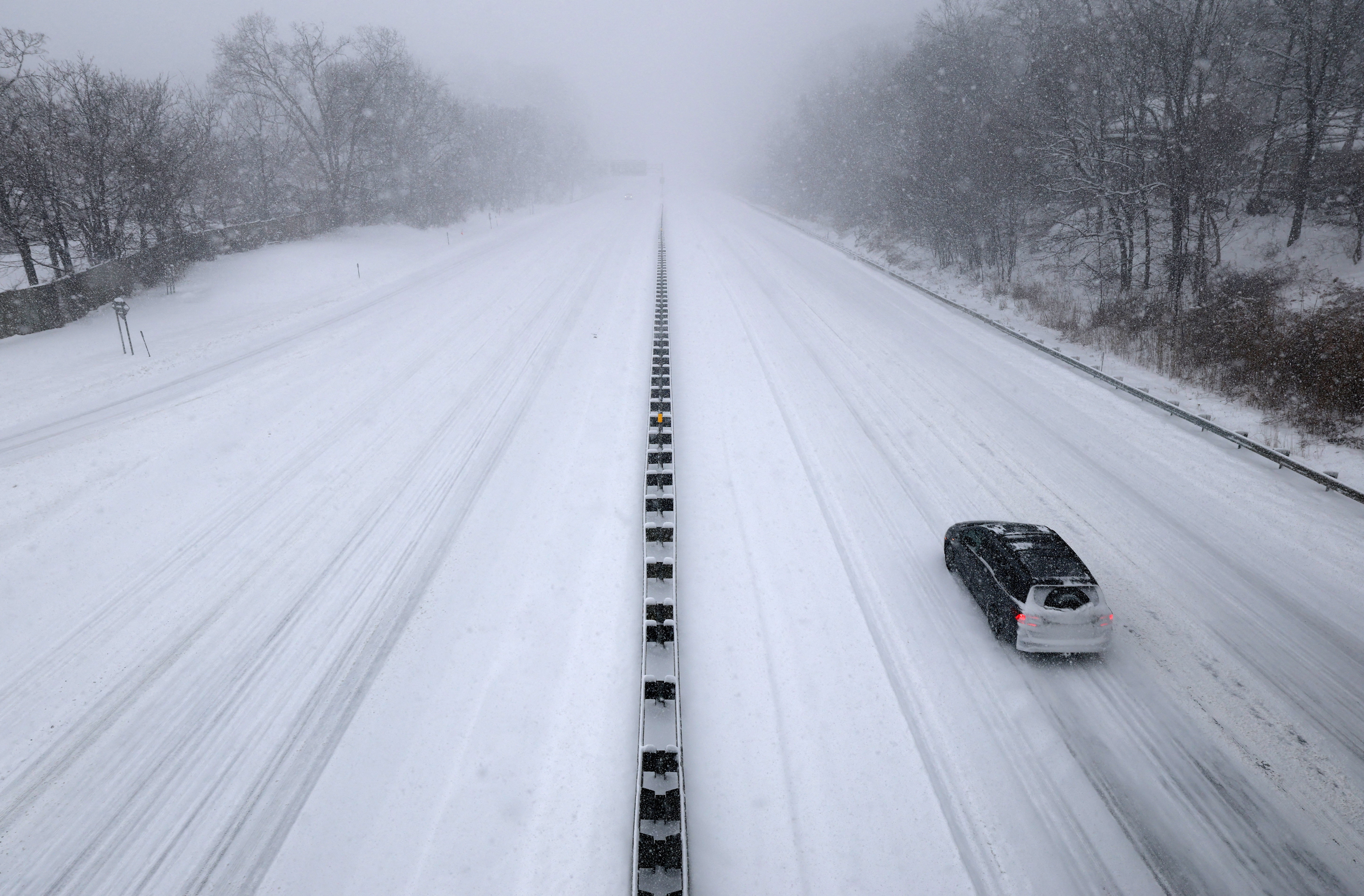 A single car travels north on the snow-covered New York State Thruway I-287 as a major winter storm spreads across a large swath of the United States, in Nyack, New York, U.S.