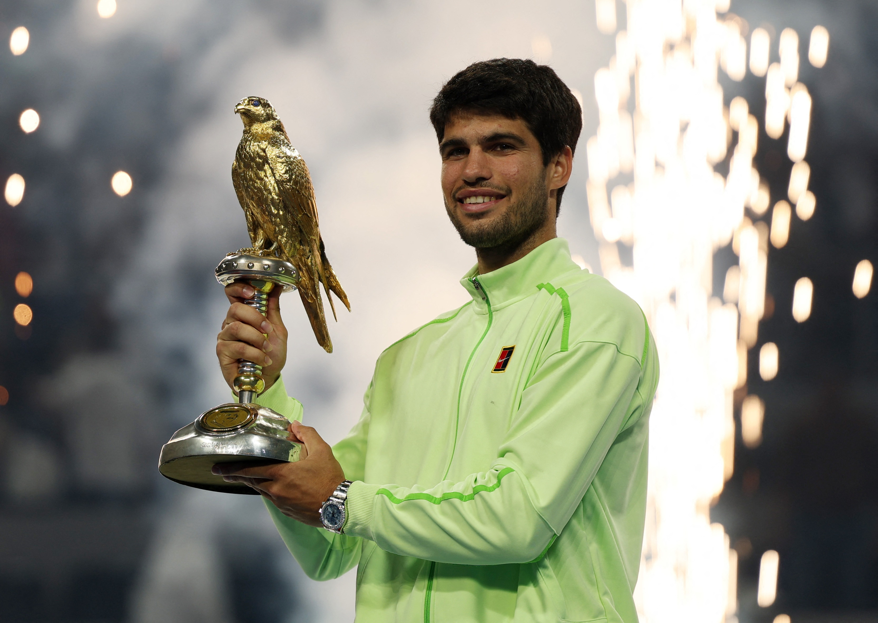 Tennis - Qatar Open - Khalifa International Tennis and Squash complex, Doha, Qatar - February 21, 2026 Spain's Carlos Alcaraz celebrates with the Qatar Open trophy after winning the final match against France's Arthur Fils REUTERS/Mohammed Salem