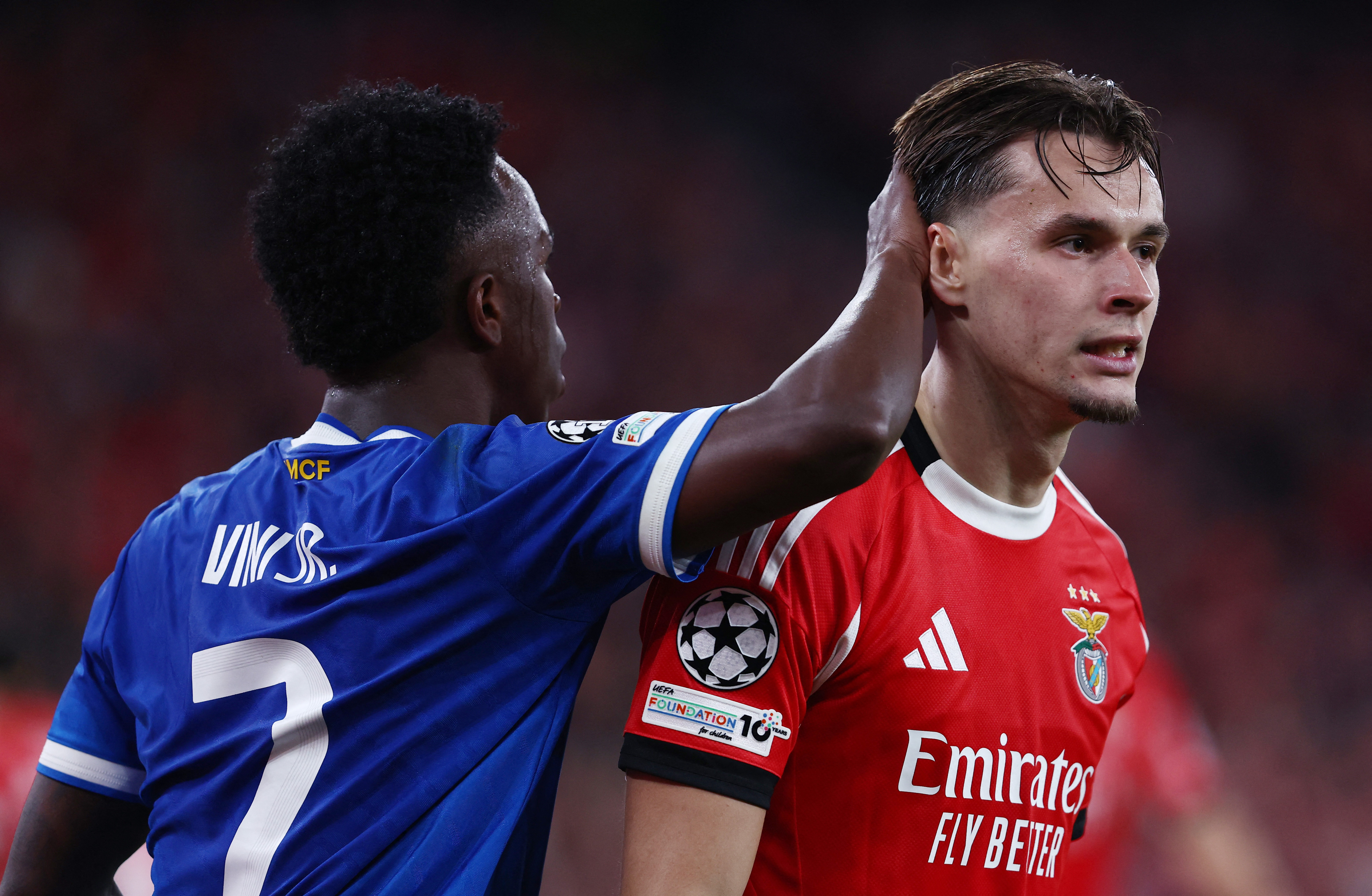 Soccer Football - UEFA Champions League - Play Off - First Leg - Benfica v Real Madrid - Estadio da Luz, Lisbon, Portugal - February 17, 2026 Real Madrid's Vinicius Junior with Benfica's Amar Dedic REUTERS/Rodrigo Antunes