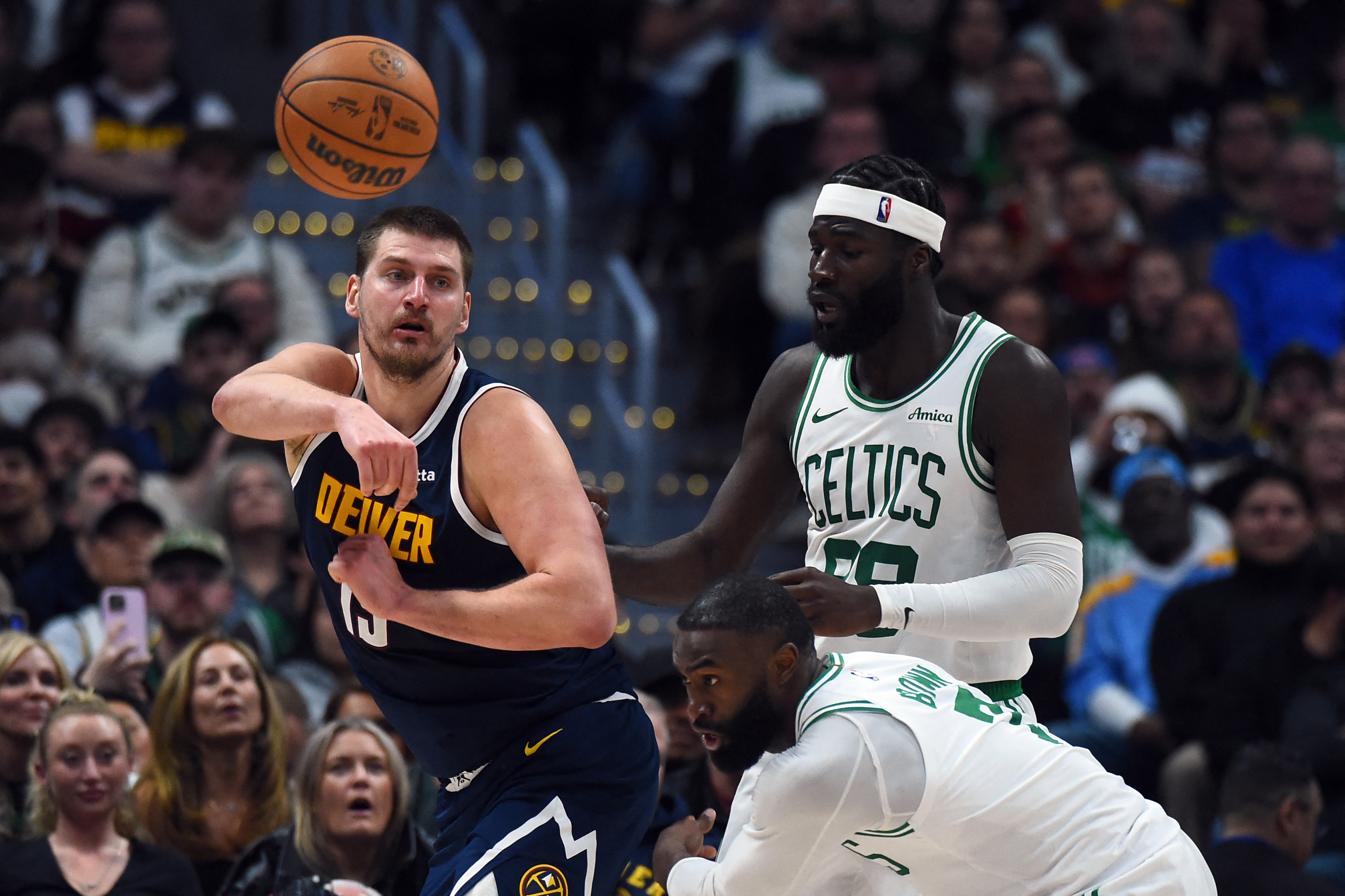 Feb 25, 2026; Denver, Colorado, USA; Denver Nuggets center Nikola Jokic (15) passes the ball as he is defended by Boston Celtics center Neemias Queta (88) during the second half at Ball Arena. Mandatory Credit: Christopher Hanewinckel-Imagn Images