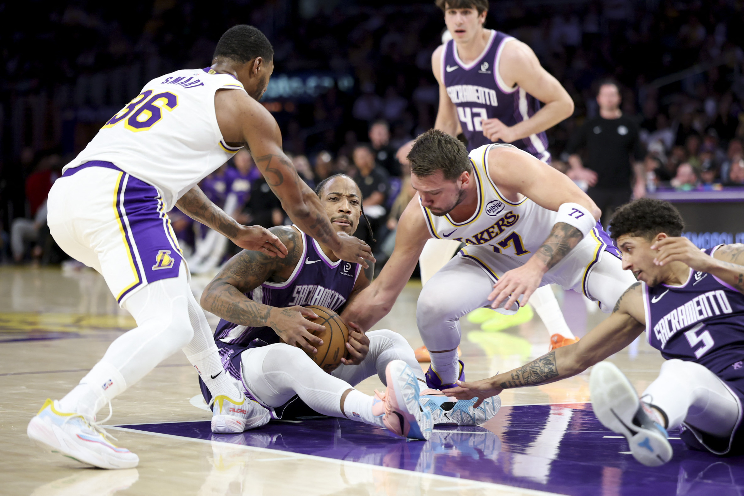 Mar 1, 2026; Los Angeles, California, USA; Sacramento Kings guard DeMar DeRozan (10) fights for the ball against Los Angeles Lakers guard Luka Doncic (77) during the first quarter at Crypto.com Arena. Mandatory Credit: William Navarro-Imagn Images