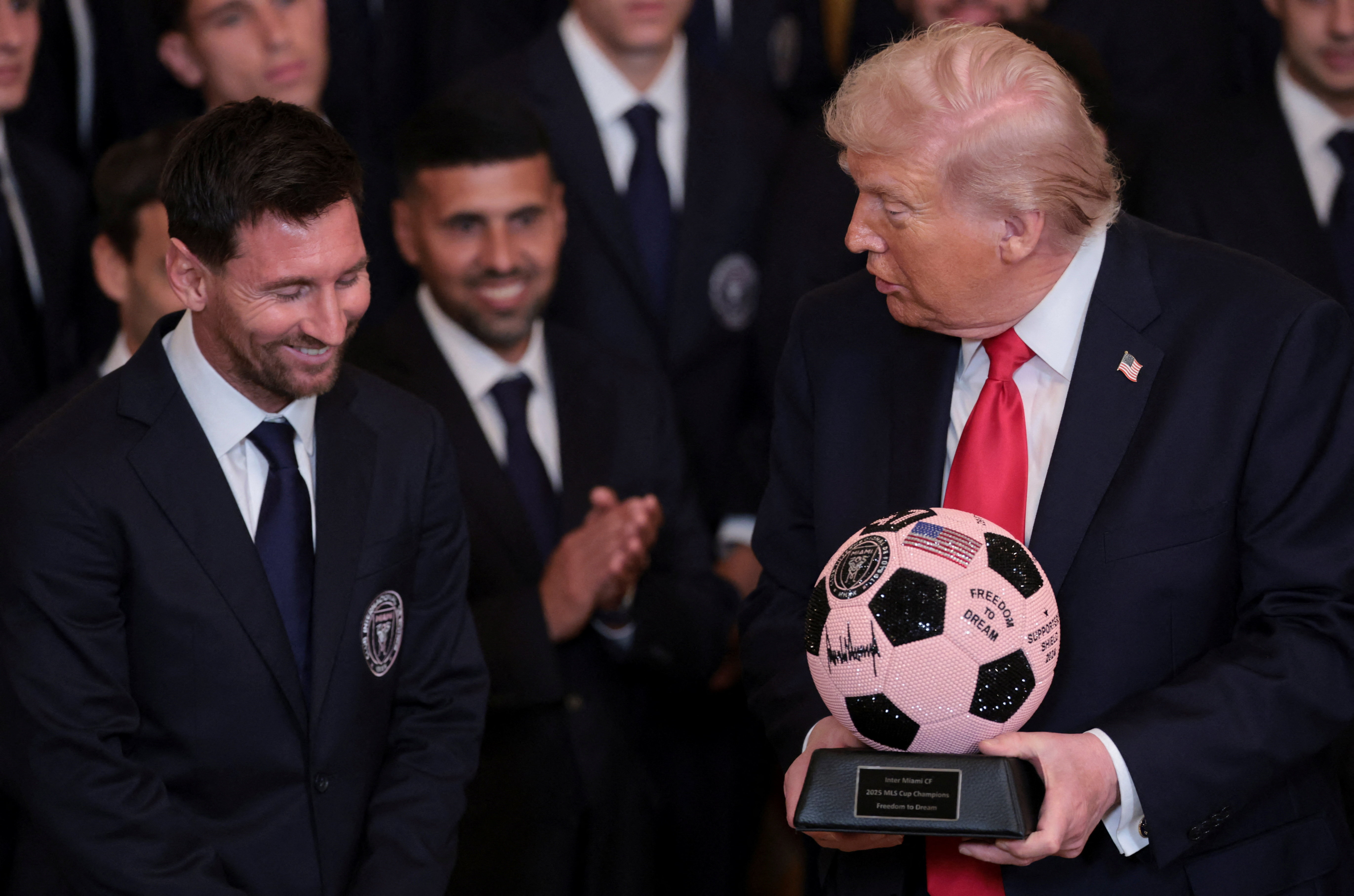 Inter Miami CF captain Lionel Messi reacts as U.S. President Donald Trump holds a jeweled soccer ball with his signature on it that was gifted to him as he honors reigning Major League Soccer (MLS) champion Inter Miami CF players and team officials with a