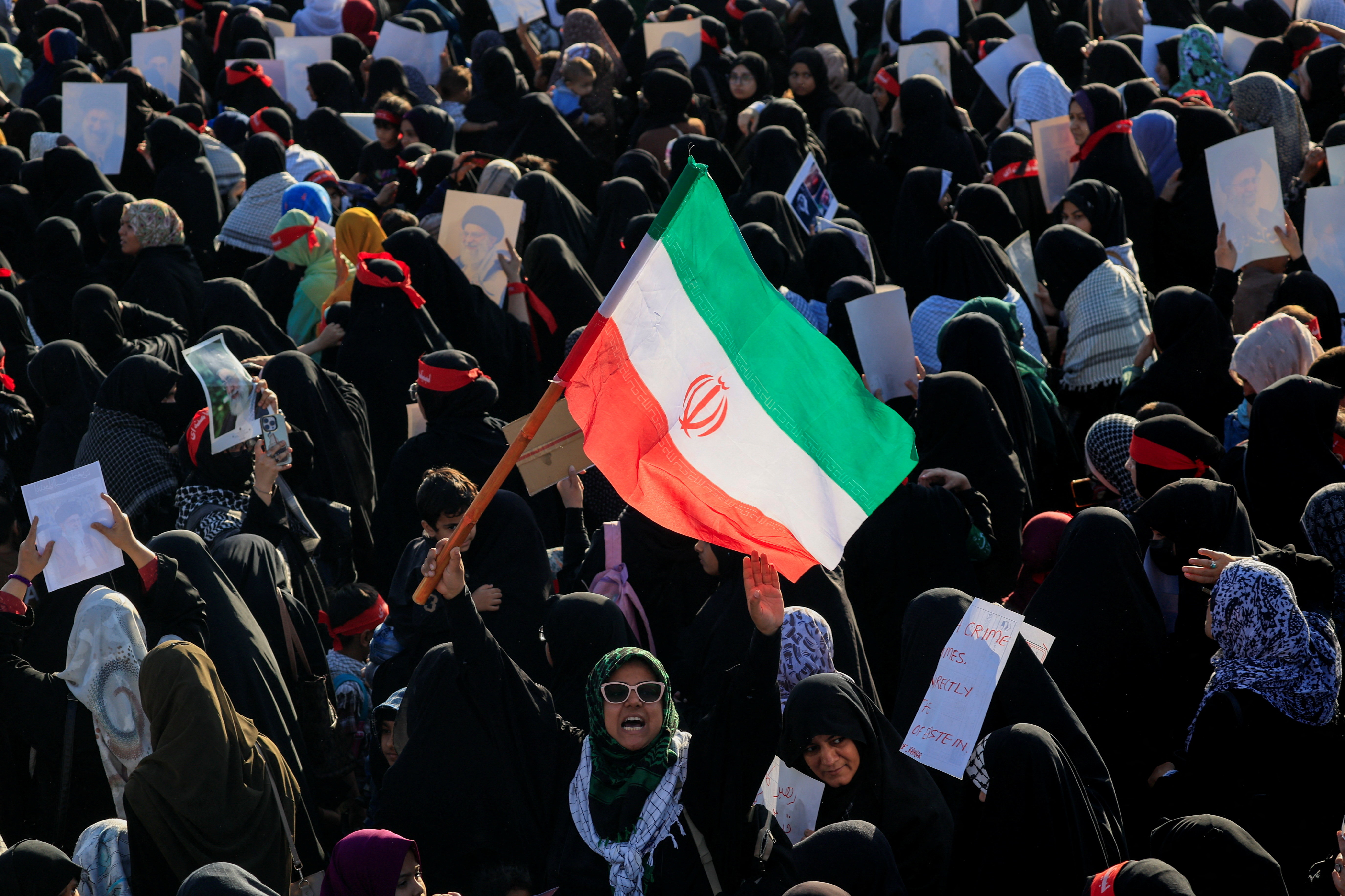 A Shiite Muslim woman chants slogans and holds an Iranian flag as she, along with others, participates in a protest, following the killing of Iran's Supreme Leader Ayatollah Ali Khamenei in U.S. and Israeli strikes on Saturday