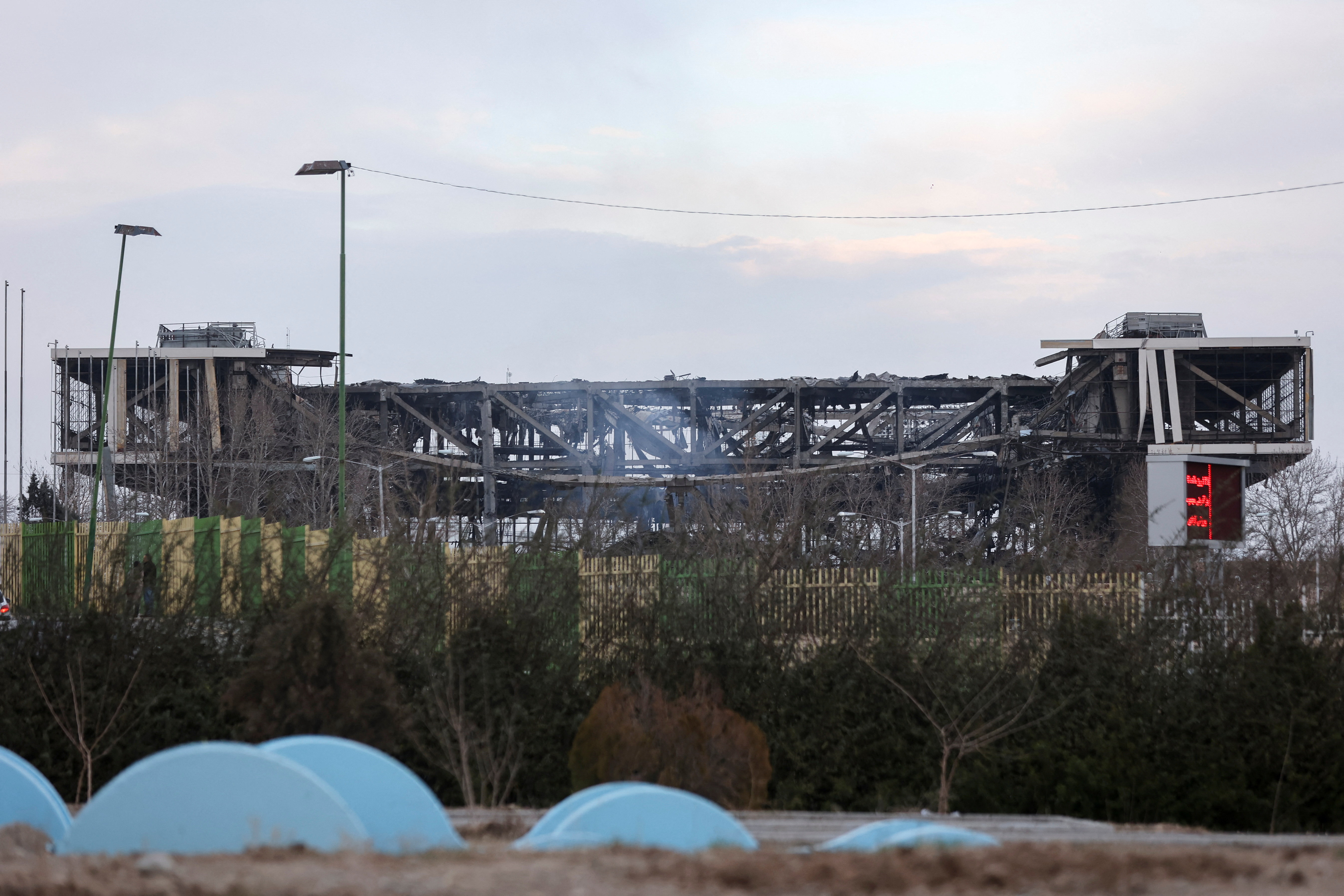 Smoke rises over damaged Azadi Stadium following an attack, amid the U.S.-Israeli
