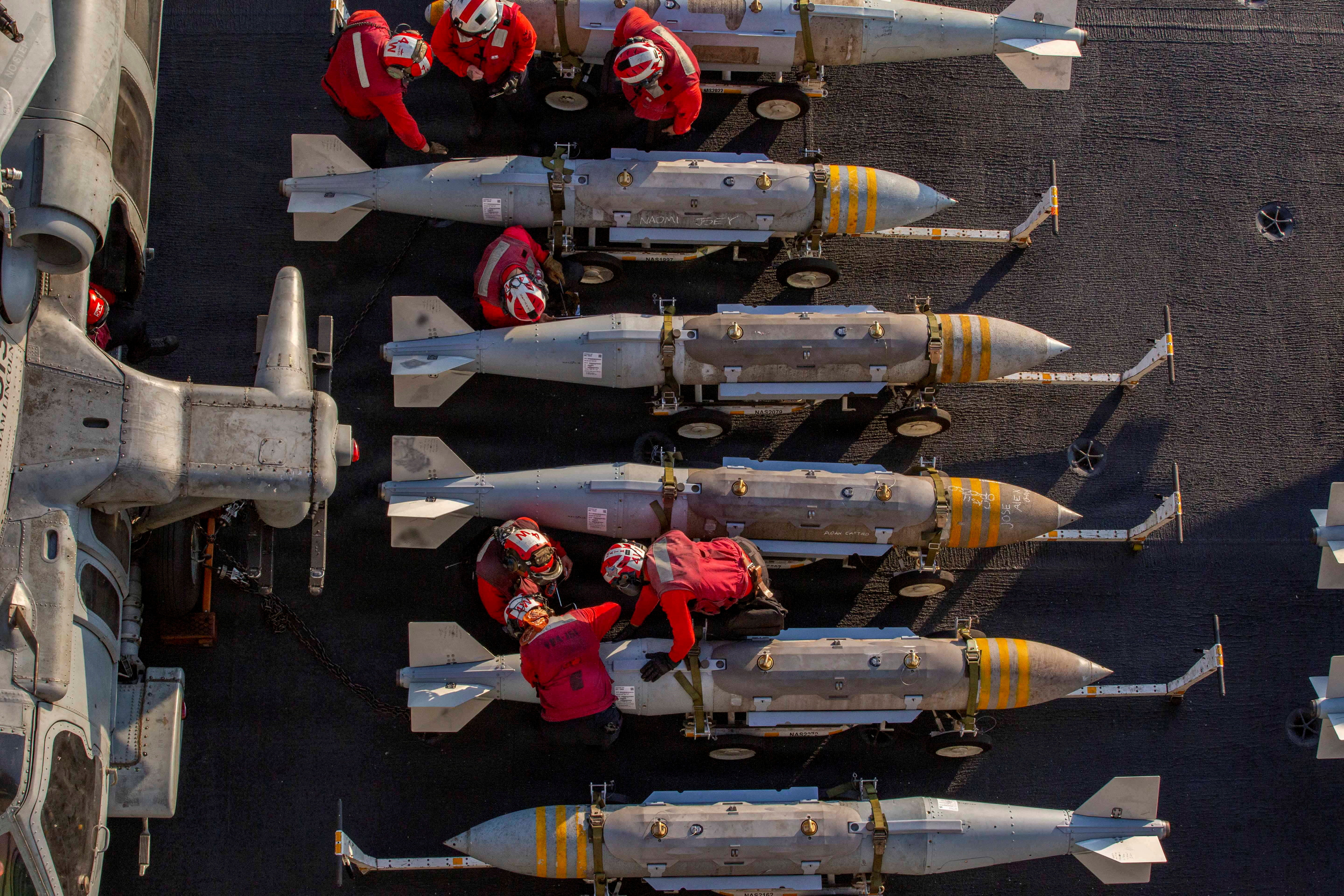 U.S. Navy sailors prepare to stage ordnance on the flight deck of the Nimitz