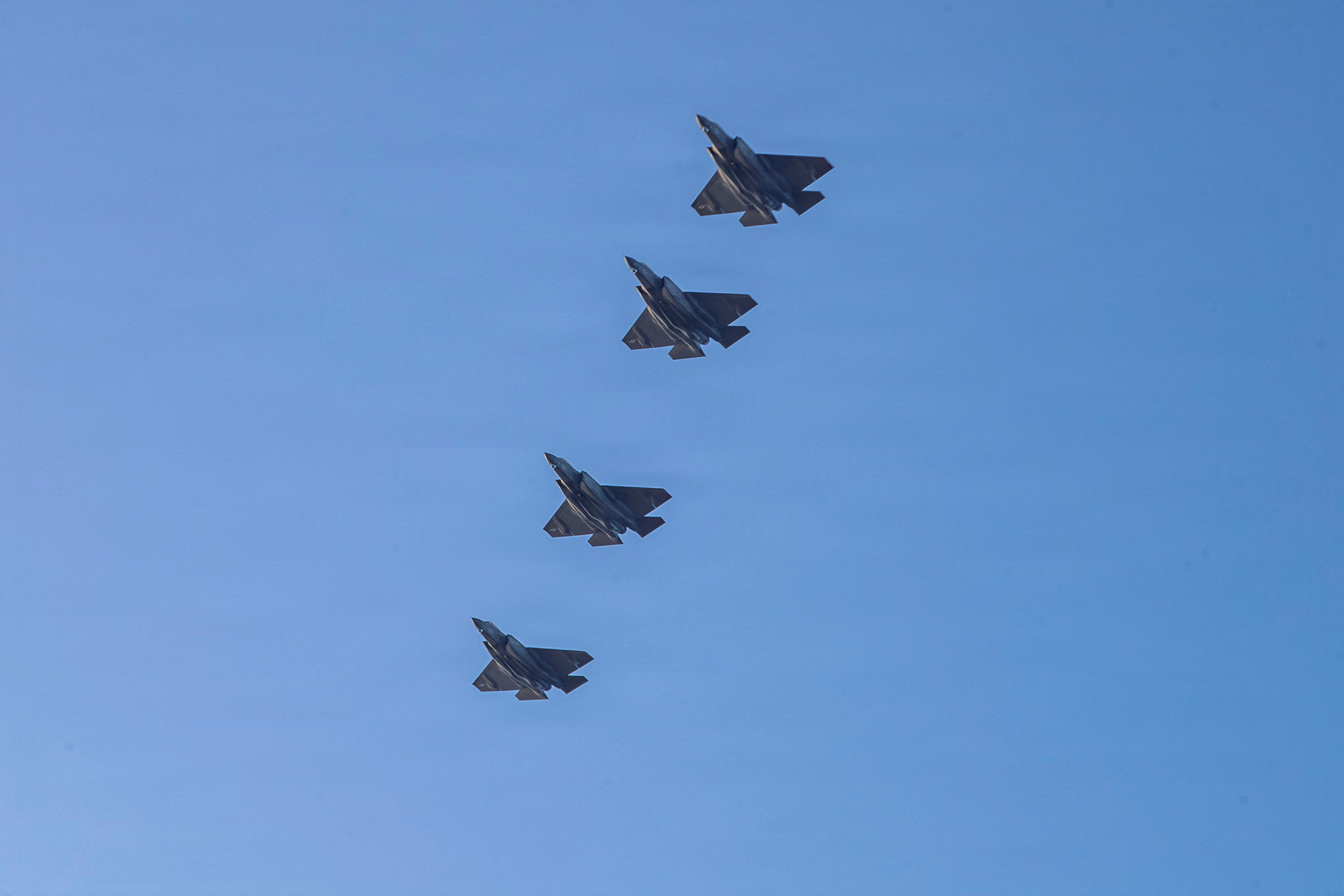 U.S. Navy aircraft fly over the flight deck of the Nimitz-class aircraft carrier