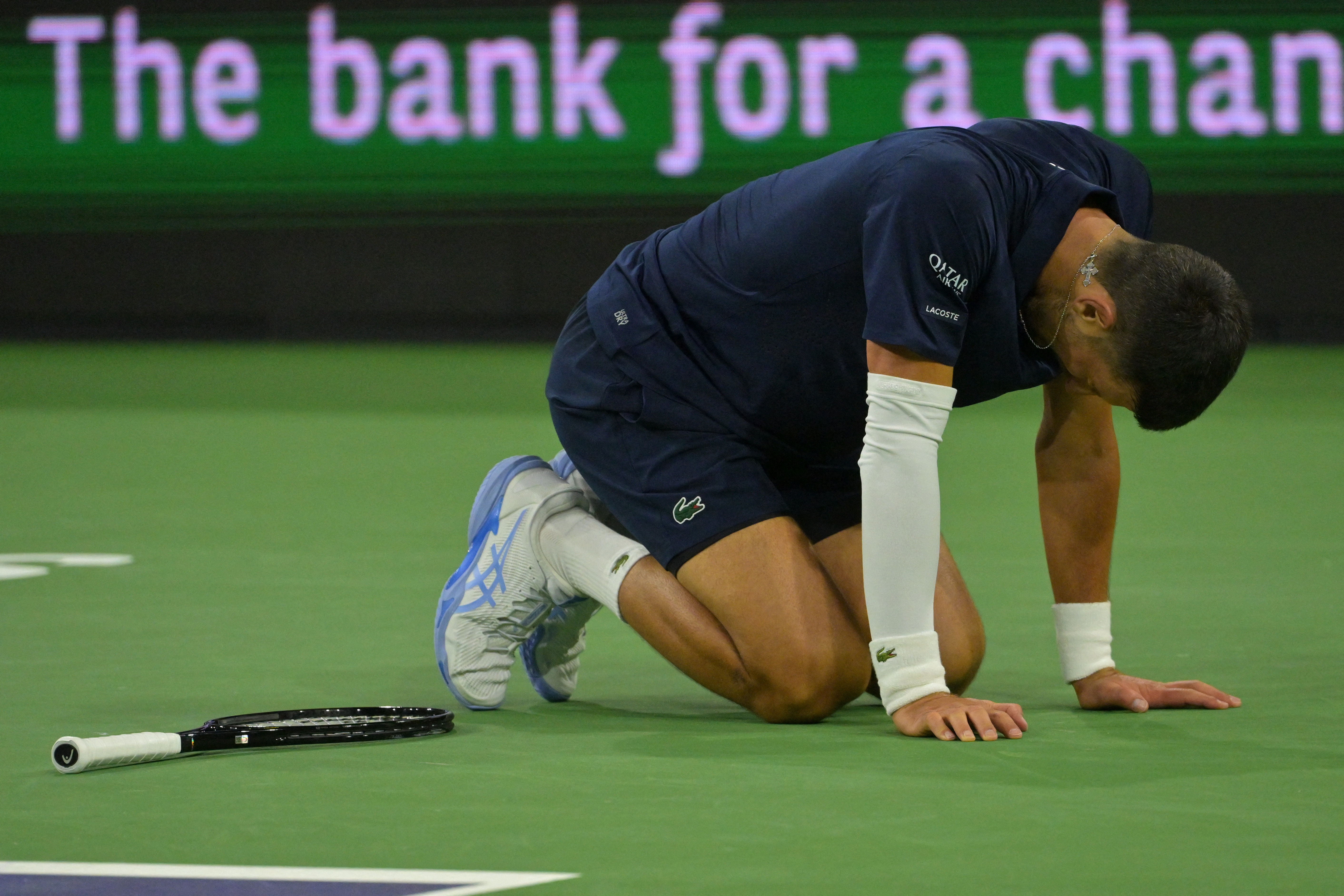 Mar 11, 2026; Indian Wells, CA, USA;  Novak Djokovic (SRB) kneels on the court after missing a shot during his fourth round match against Jack Draper (GBR) in the BNP Paribas Open at the Indian Wells Tennis Garden. Mandatory Credit: Jayne Kamin-Oncea-Imag