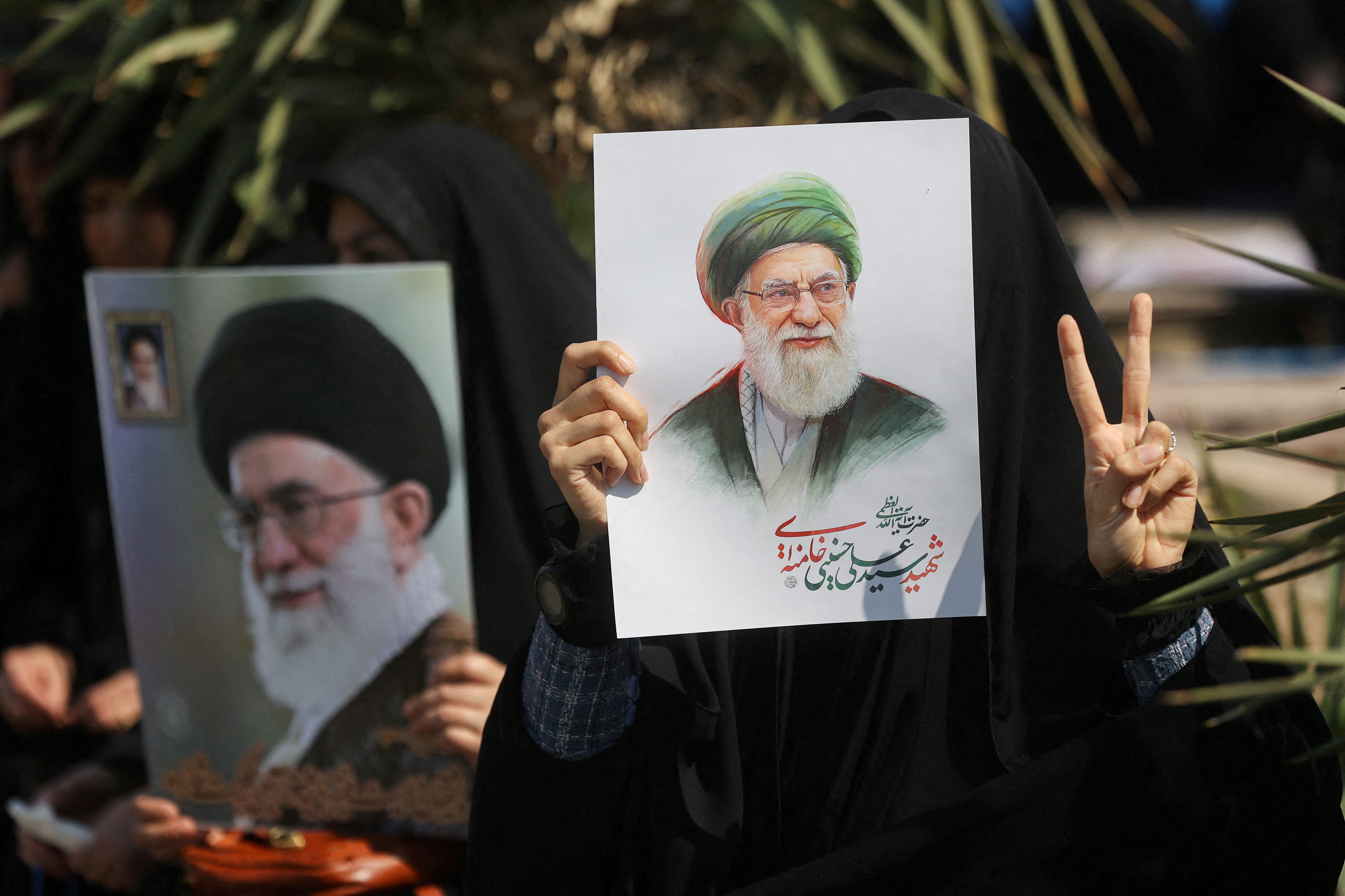 FILE PHOTO: A woman gestures while holding an image of Iran'