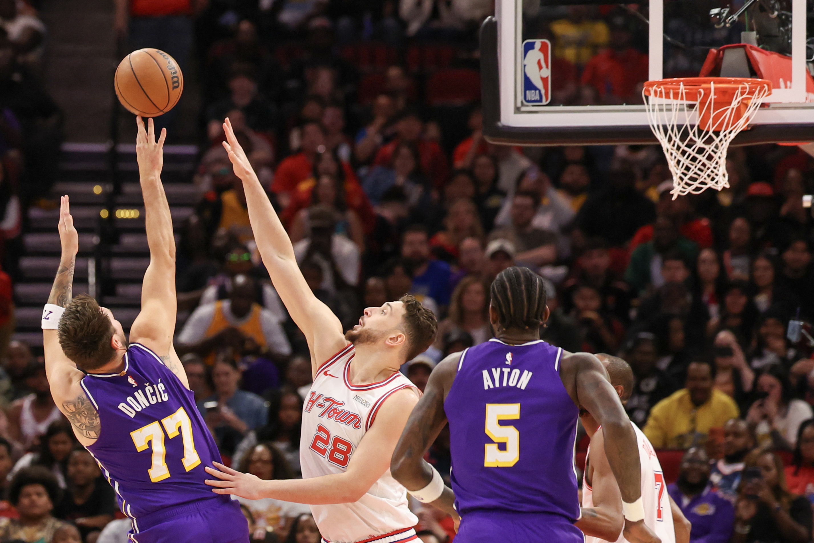 Mar 18, 2026; Houston, Texas, USA;  Los Angeles Lakers guard Luka Doncic (77) shoots over Houston Rockets center Alperen Sengun (28) in the first quarter at Toyota Center. Mandatory Credit: Thomas Shea-Imagn Images