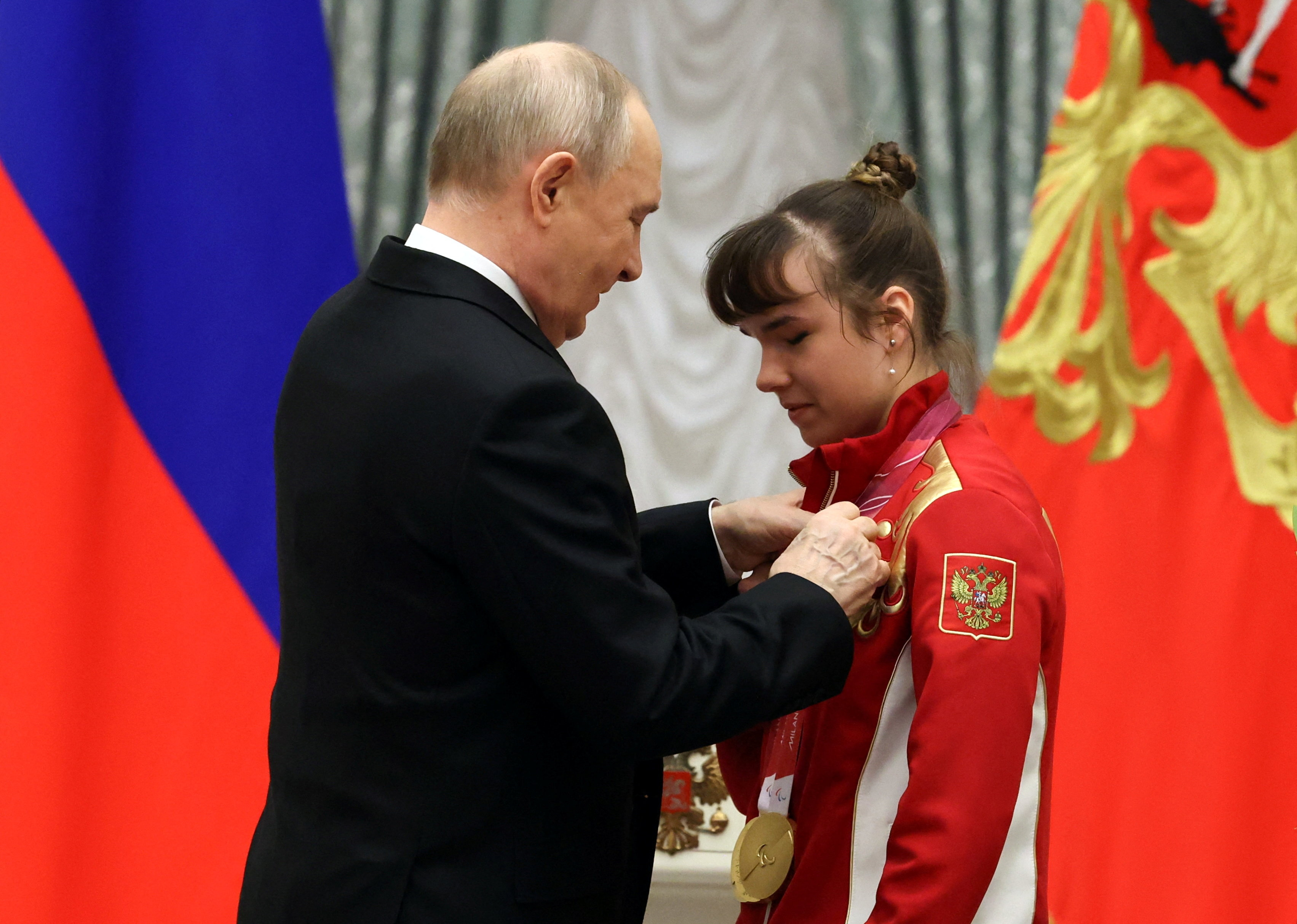 Russia's President Vladimir Putin decorates para cross-country skier and three-time Paralympic champion Anastasia Bagiyan with the Order of Friendship during a ceremony to award members of the Russian Paralympic team, who took part in the 2026 Winter Para