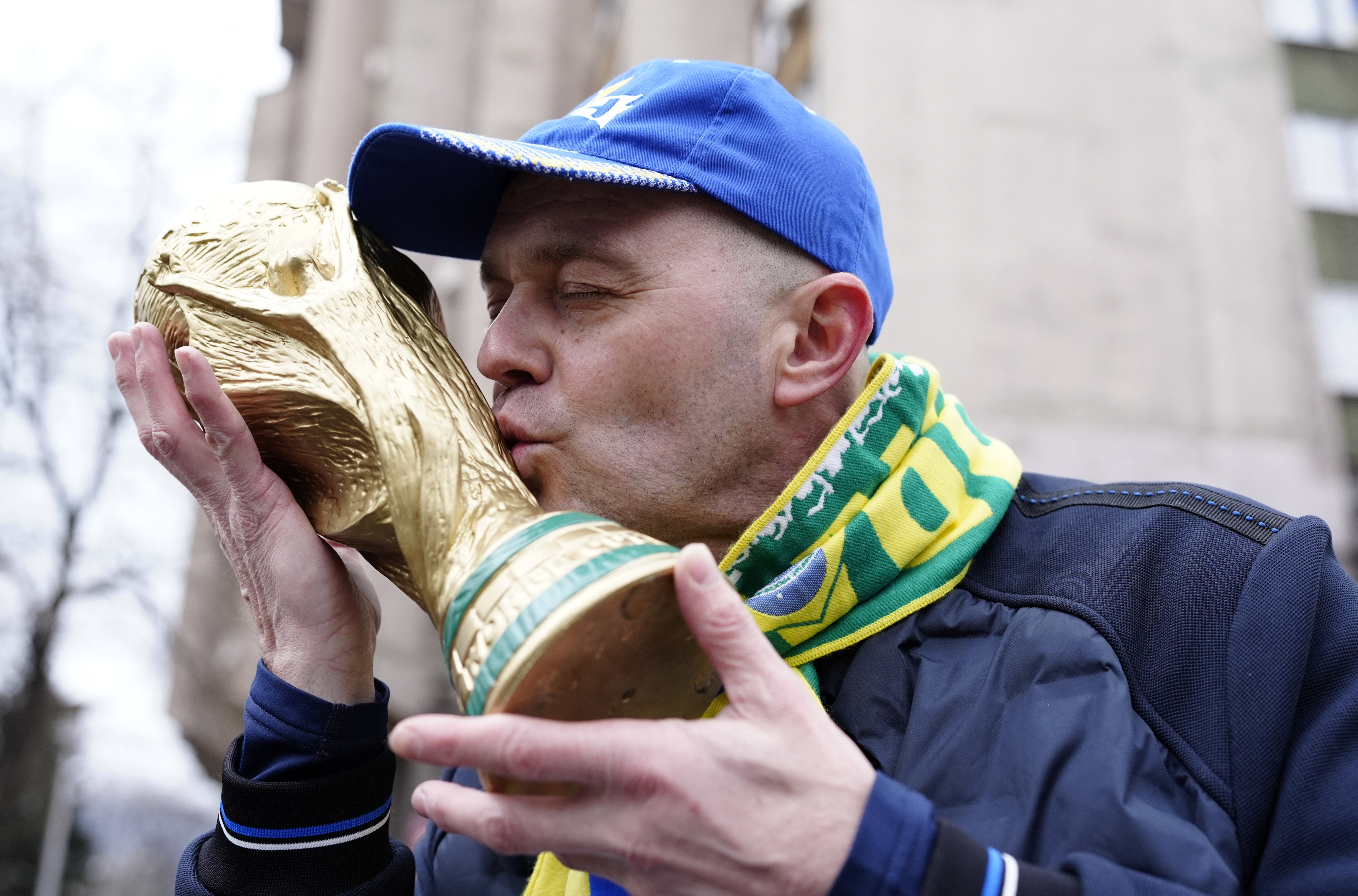 2026-03-Soccer Football - FIFA World Cup - UEFA Qualifiers - Finals - Bosnia and Herzegovina v Italy - Zenica, Bosnia and Herzegovina - March 31, 2026 A Bosnia and Herzegovina fan holds and kisses a FIFA World Cup trophy replica outsi-WORLDCUP-BIH-ITA.JPG