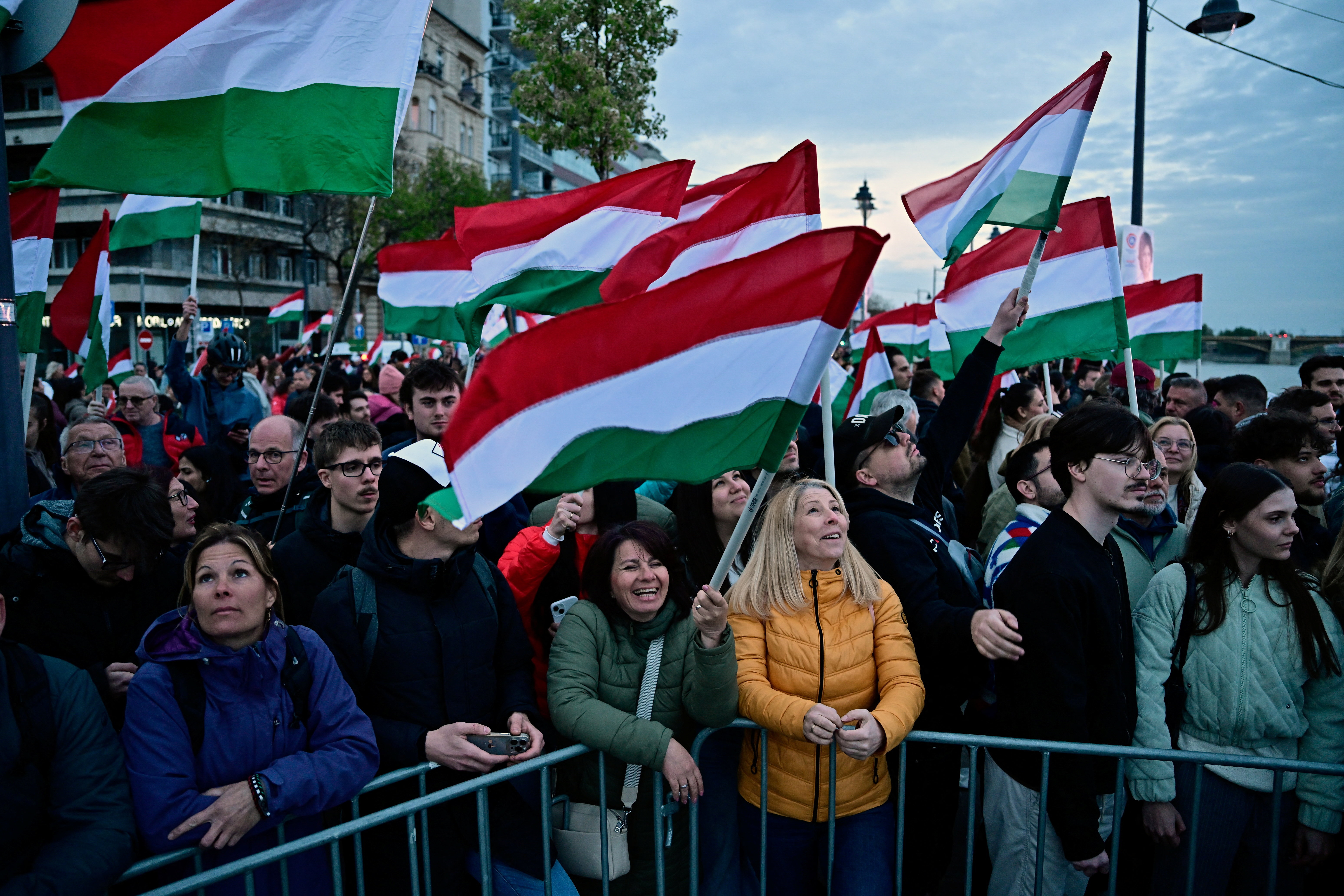 People hold Hungarian flags, as they wait for Peter Magyar, leader of the opposition Tisza party, on the day of the parliamentary election, in Budapest, Hungary, April 12, 2026. REUTERS/Marton Monus