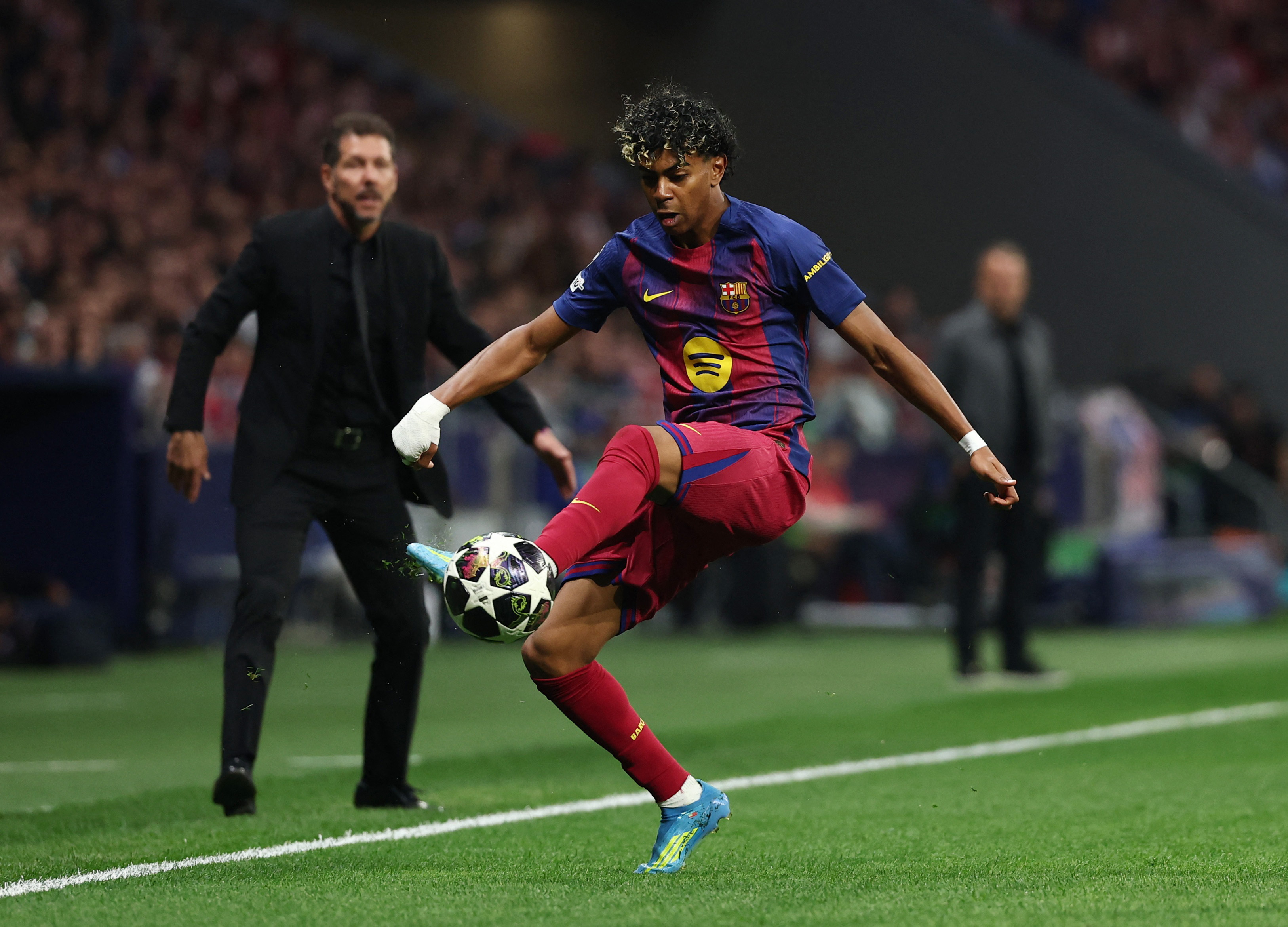 Soccer Football - UEFA Champions League - Quarter Final - Second Leg - Atletico Madrid v FC Barcelona - Riyadh Air Metropolitano, Madrid, Spain - April 14, 2026 FC Barcelona's Lamine Yamal in action as Atletico Madrid coach Diego Simeone looks on REUTERS/