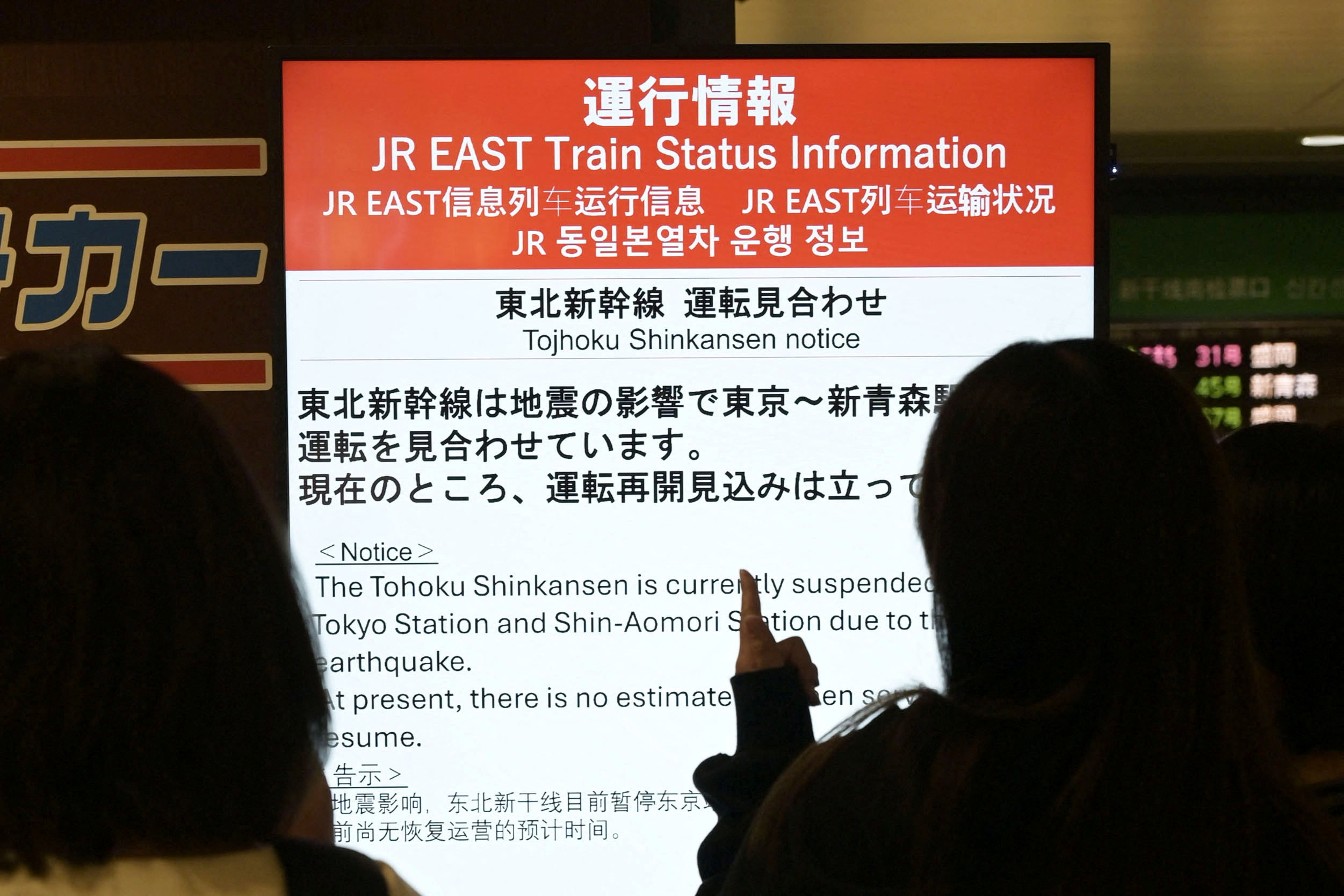 People look at an electronic display announcing suspension