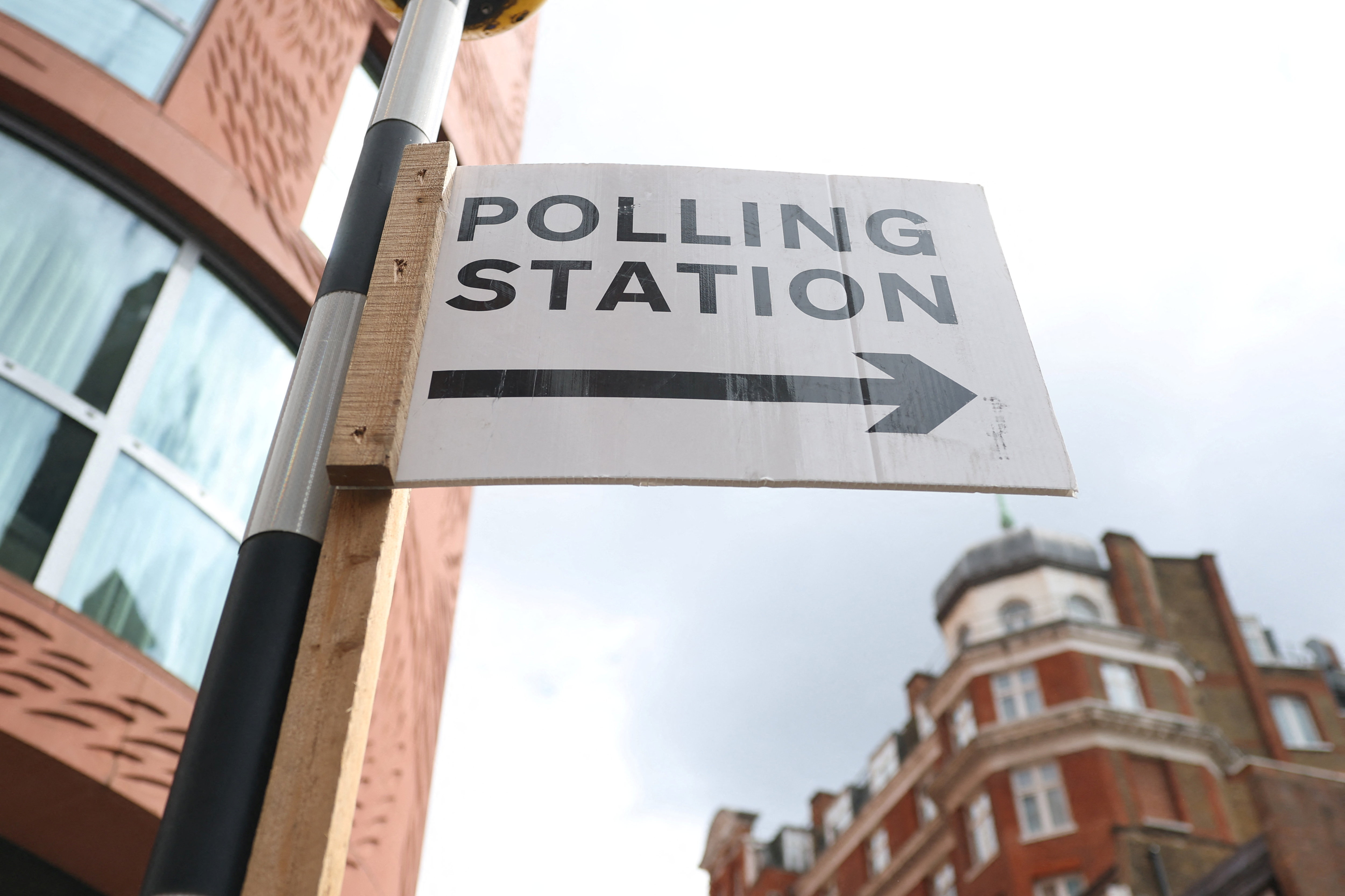 A polling station direction sign is attached to a pedestrian crossing ahead of upcoming local and mayoral elections in England and devolved parliamentary elections in Wales and Scotland on May 7, in London, Britain, May 6, 2026. REUTERS/Toby Melville