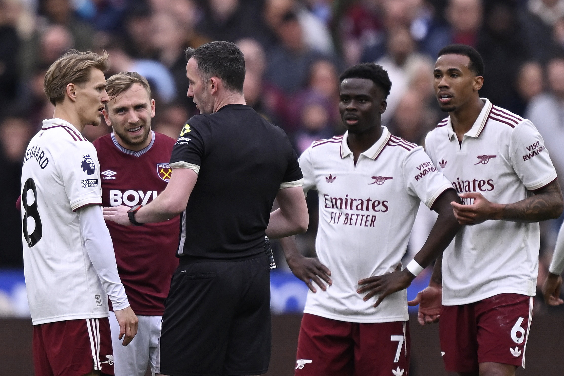 Soccer Football - Premier League - West Ham United v Arsenal - London Stadium, London, Britain - May 10, 2026 Arsenal's Martin Odegaard and West Ham United's Jarrod Bowen with referee Chris Kavanagh as Arsenal's Bukayo Saka and Gabriel Magalhaes look on R