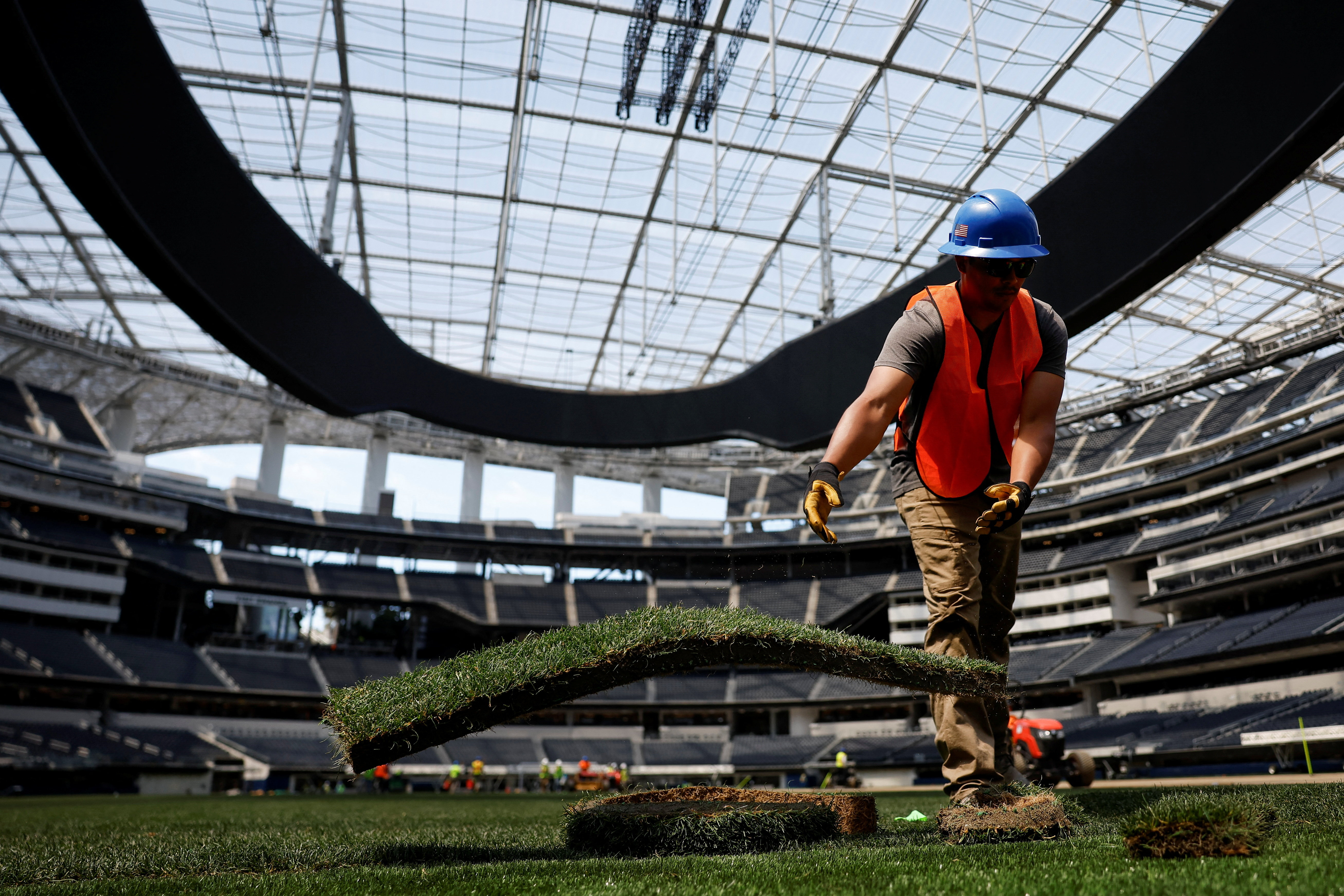 A worker installs a patch of grass to be used as part of the pitch at SoFi Stadium, ahead of the FIFA World Cup soccer tournament, in Inglewood, California, U.S, May 13, 2026.  REUTERS/Caroline Brehman     TPX IMAGES OF THE DAY