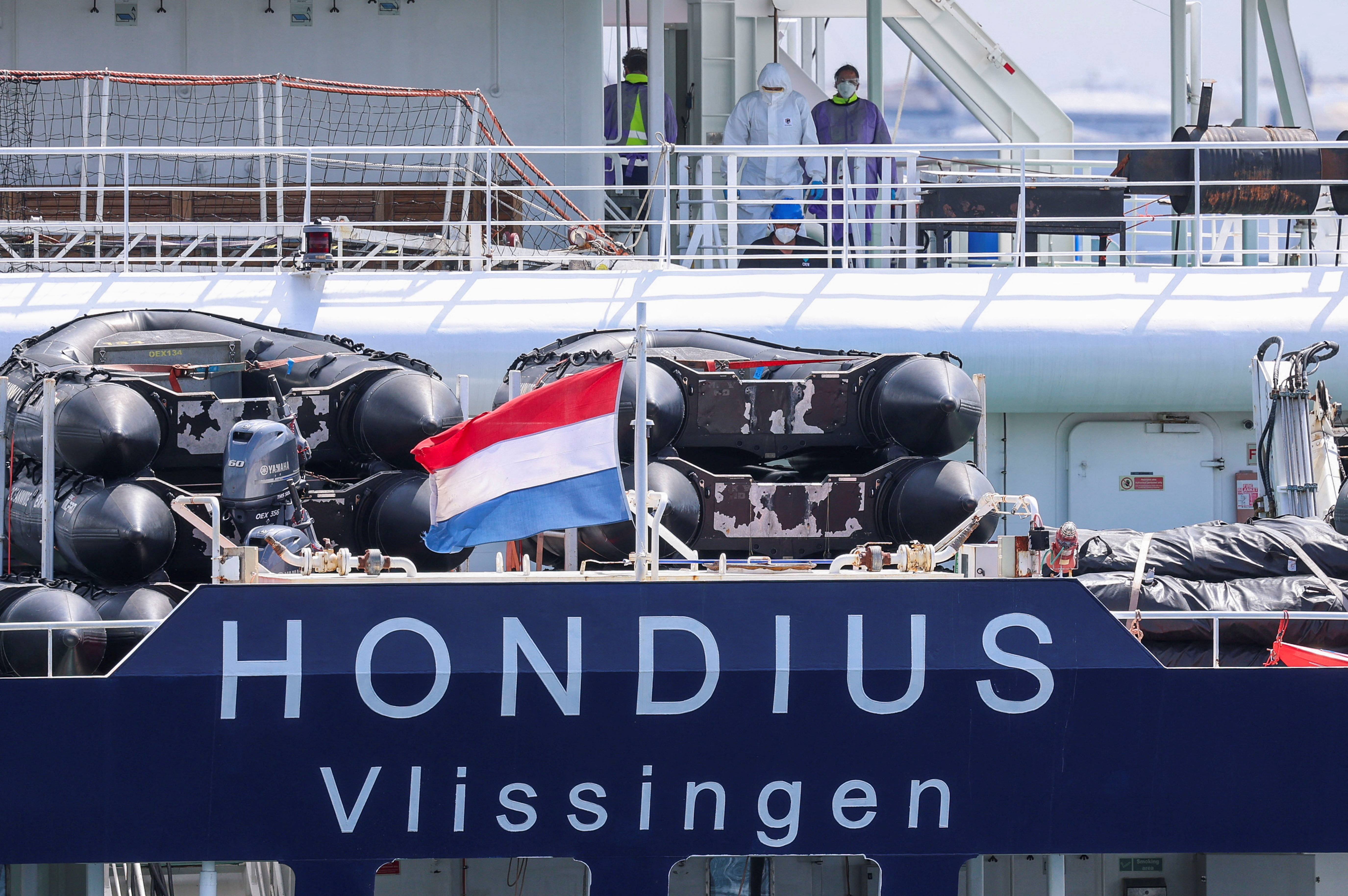 People in personal protective suits on board the cruise ship MV Hondius